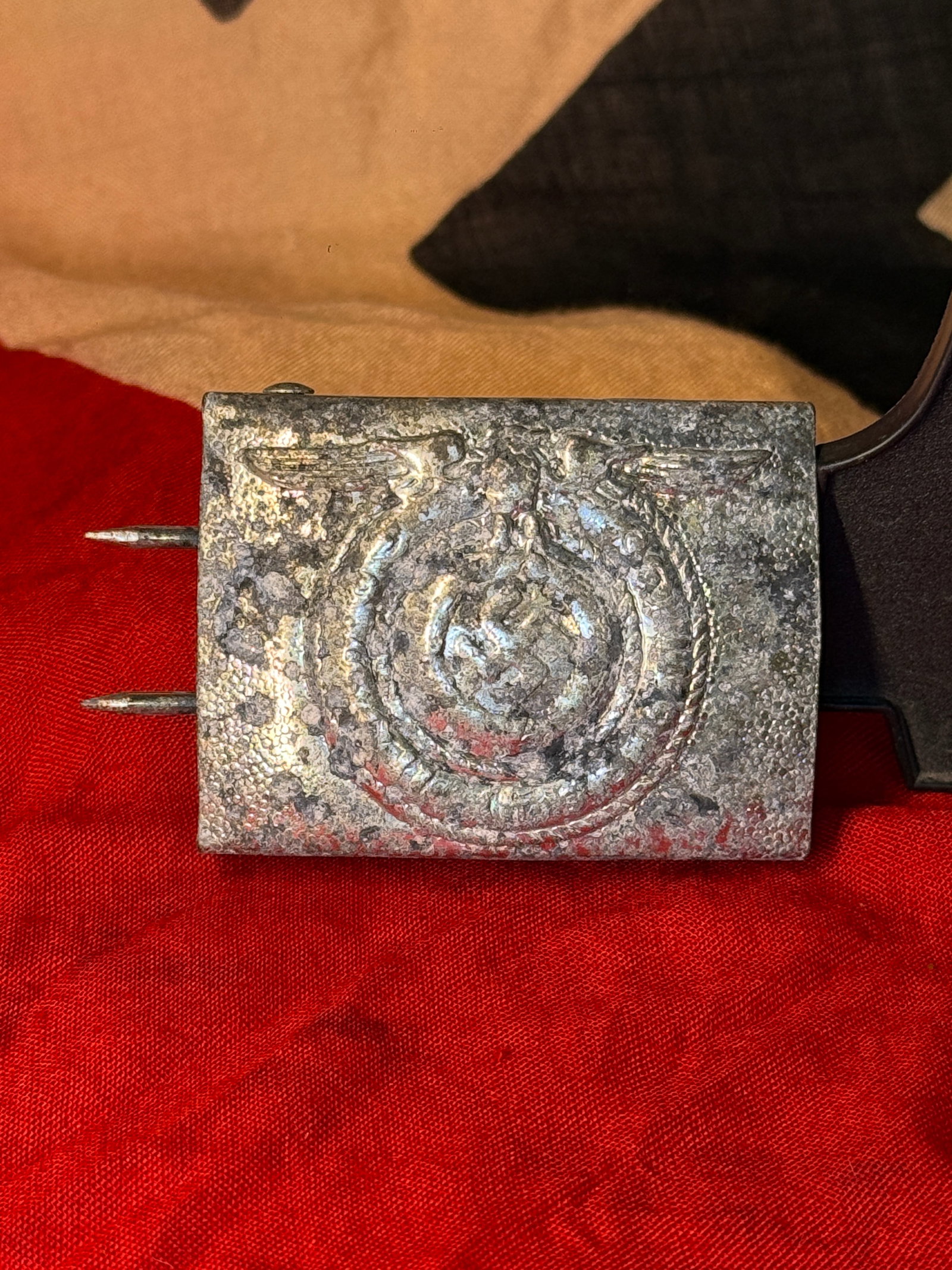 WWII German SS Officer Belt Buckle RZM 36 Eagle & Swastika: This WWII German-style SS officer belt buckle features a rectangular silver-tone metal construction with a textured field and a raised central design depicting a spread-wing eagle positioned above a w