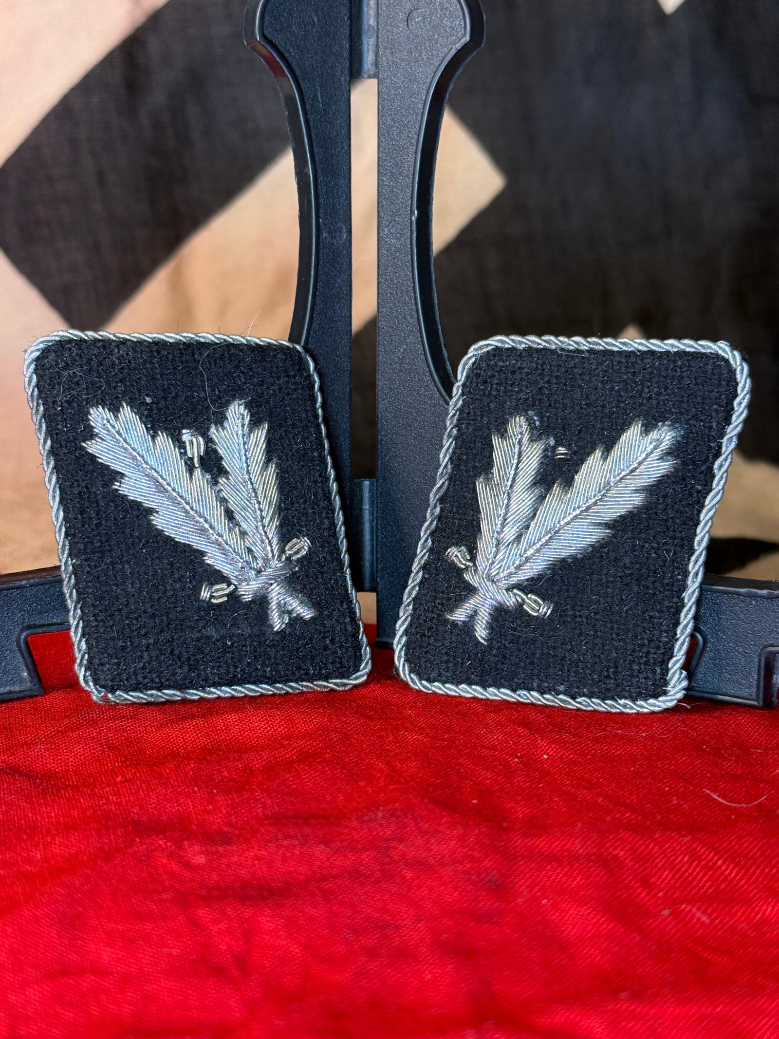 WWII German Political-Organization Waffen SS Official’s Silver-Bullion Collar Tabs with RZM Label: Pair of rectangular black wool collar tabs decorated with matching hand-embroidered silver-bullion feather or quill devices and bordered by twisted silver cord. The reverse sides retain black wool bac
