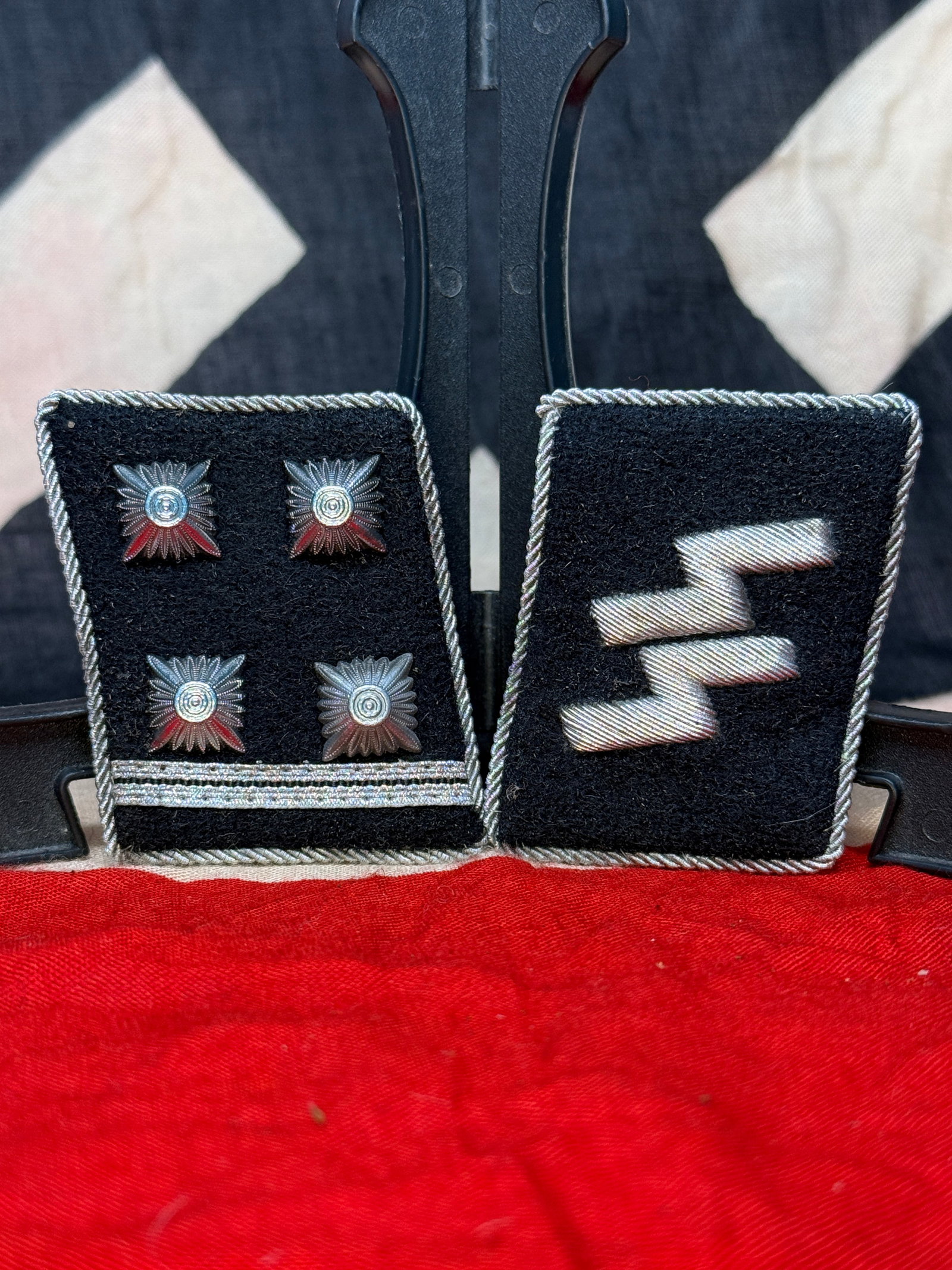 WWII German SS General-Officer Collar Tab Pair with RZM Tag: Matched black wool SS collar-tab set, edged in silver twisted cord. One tab is embroidered with four rank pips and a double bar, while the companion tab bears paired silver rank leaves, denoting a sen