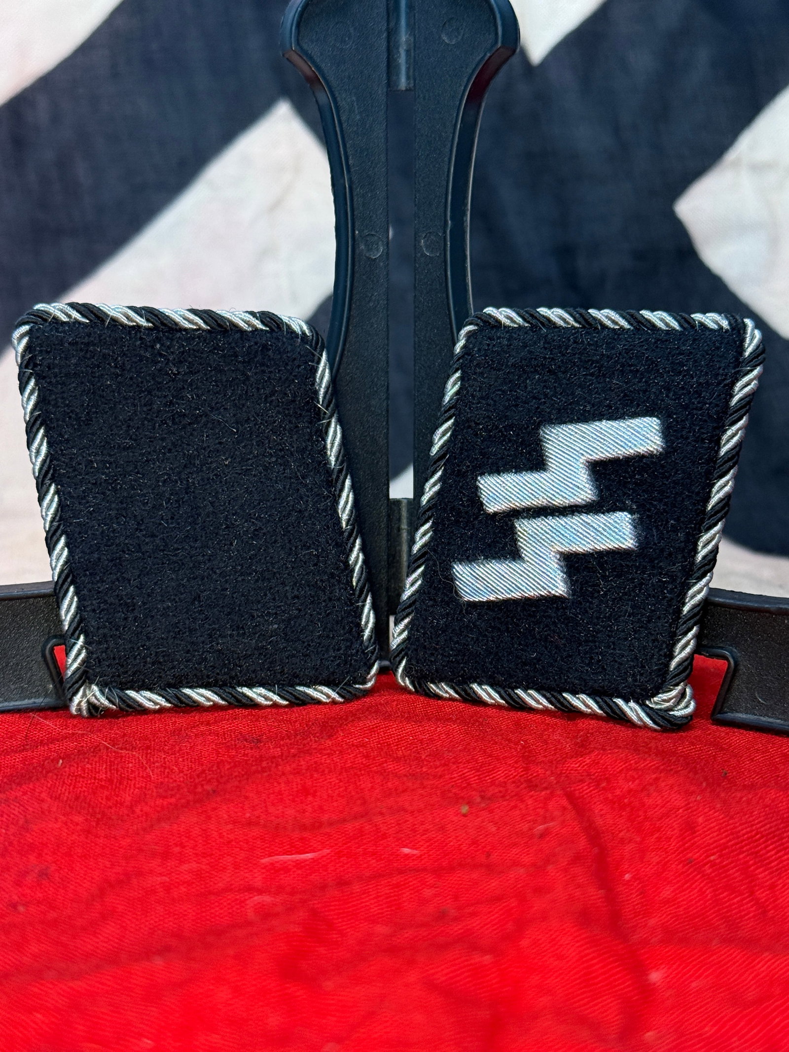 WWII German Waffen-SS Collar Tabs with RZM Tag: This matching pair of black wool Waffen-SS collar tabs includes one tab bearing the embroidered SS runes in silver-gray thread and a matching blank rank tab, both finished with silver-and-black twiste