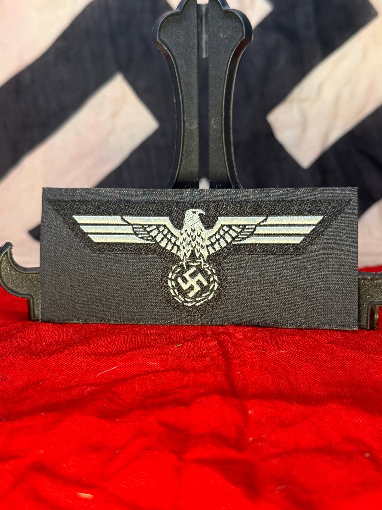 WWII German Heer Panzer Beret Eagle Insignia: This machine-woven insignia depicts the German national eagle clutching a wreath enclosing a swastika on a black cloth backing, identifying it as a Heer Panzer Beret Eagle Insignia worn on the early a