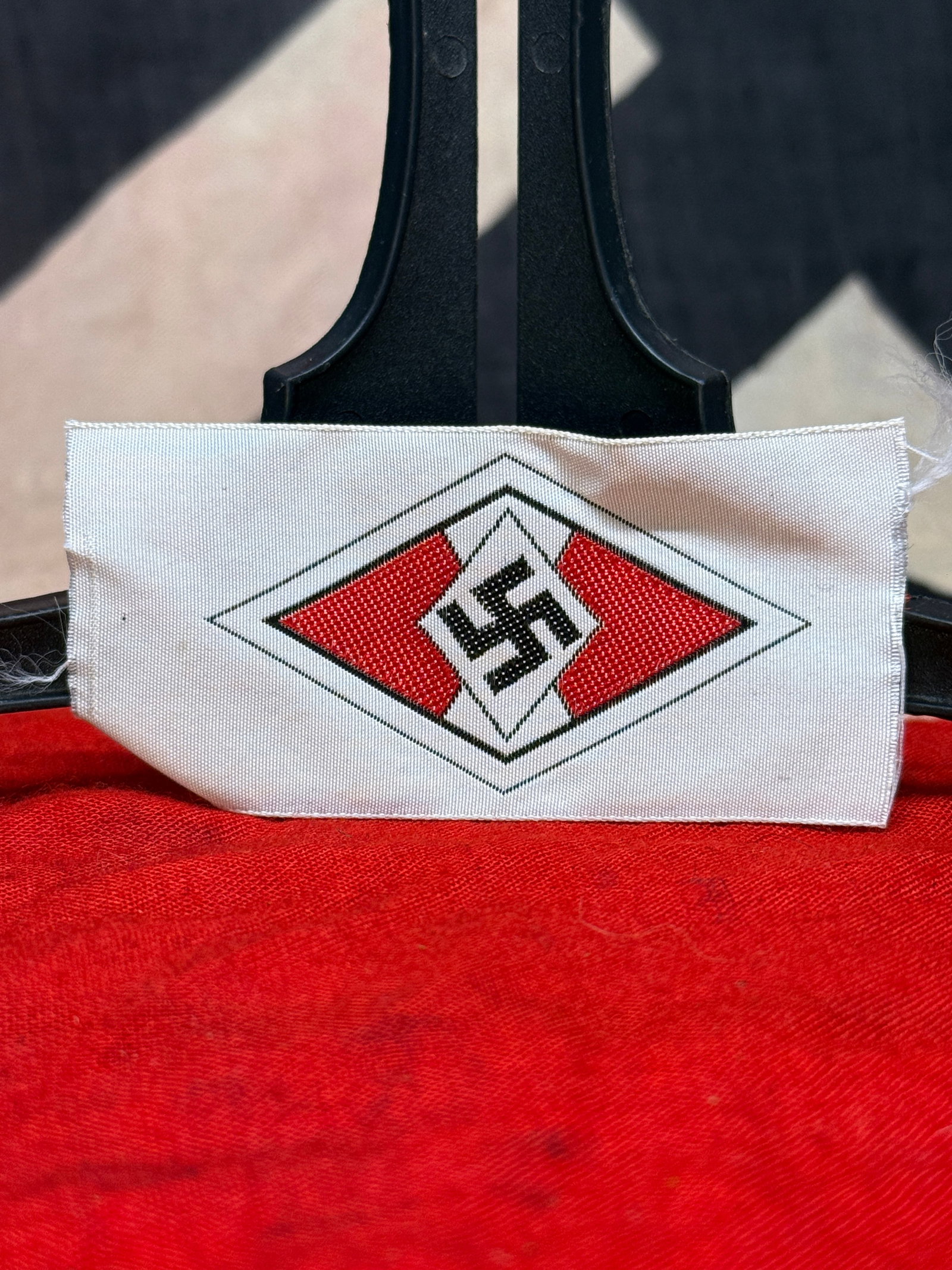 WWII German Hitler Youth (Hitlerjugend) Membership Cap Badge: This white cloth cap badge features the distinctive red and white diamond with black swastika emblem of the Hitler Youth (Hitlerjugend) woven directly into the fabric. The reverse displays the charact