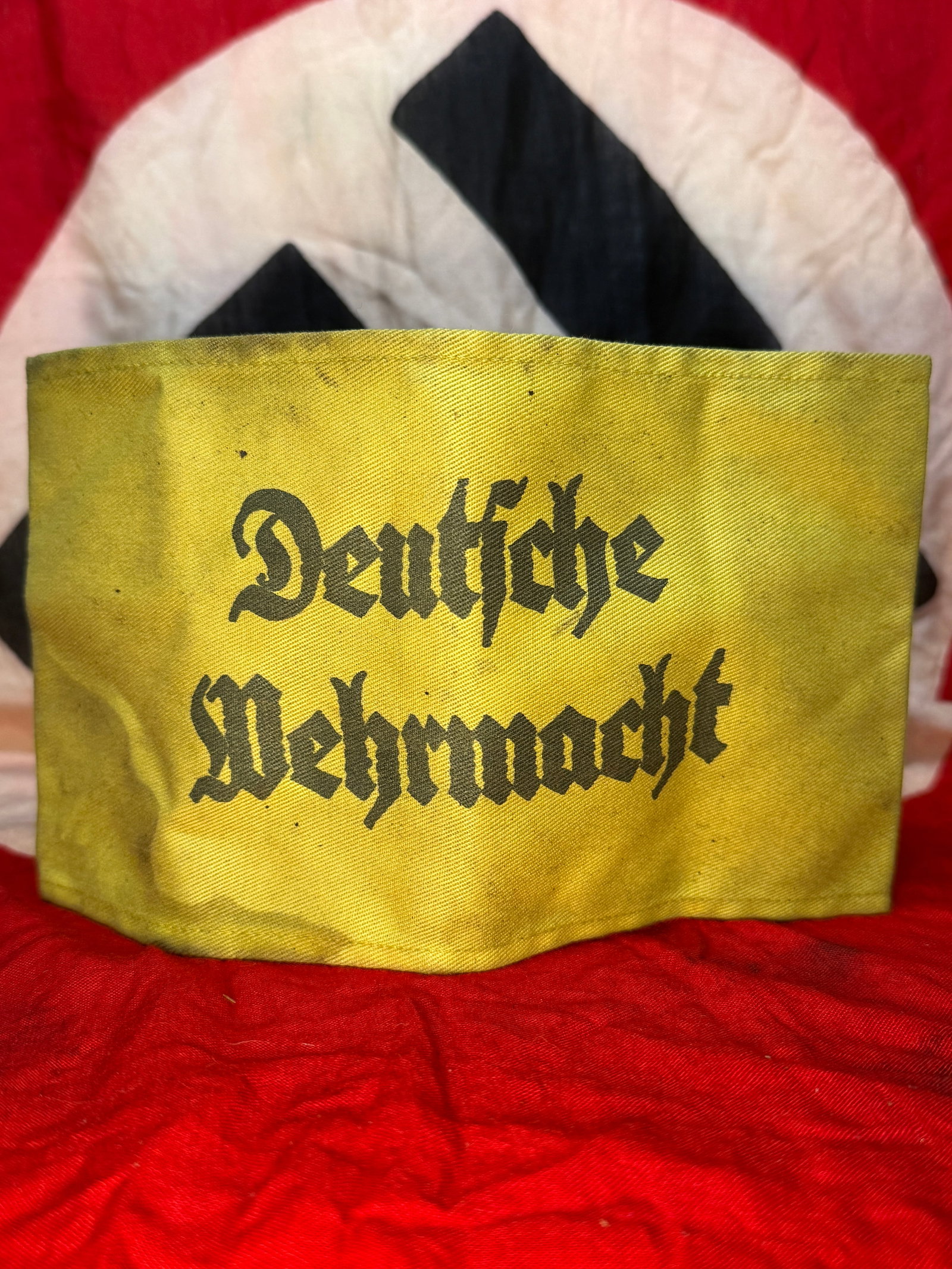 WWII German "Deutsche Wehrmacht" Armband: This yellow cloth armband is printed in black Gothic script with the words "Deutsche Wehrmacht" across the front. Constructed of heavy cotton fabric with machine-sewn edges and a vertical seam on the 