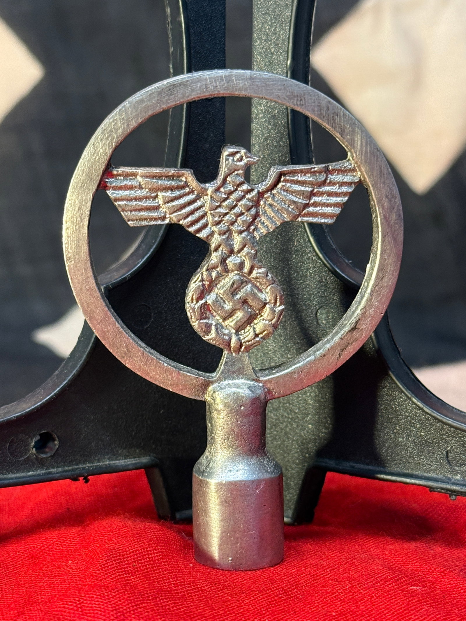 WWII German Reichsadler Flag Pole Finial: This WWII German Reichsadler flag pole finial features the national eagle with outstretched wings clutching a wreath beneath, enclosed within a circular frame and mounted on a cylindrical socket desig