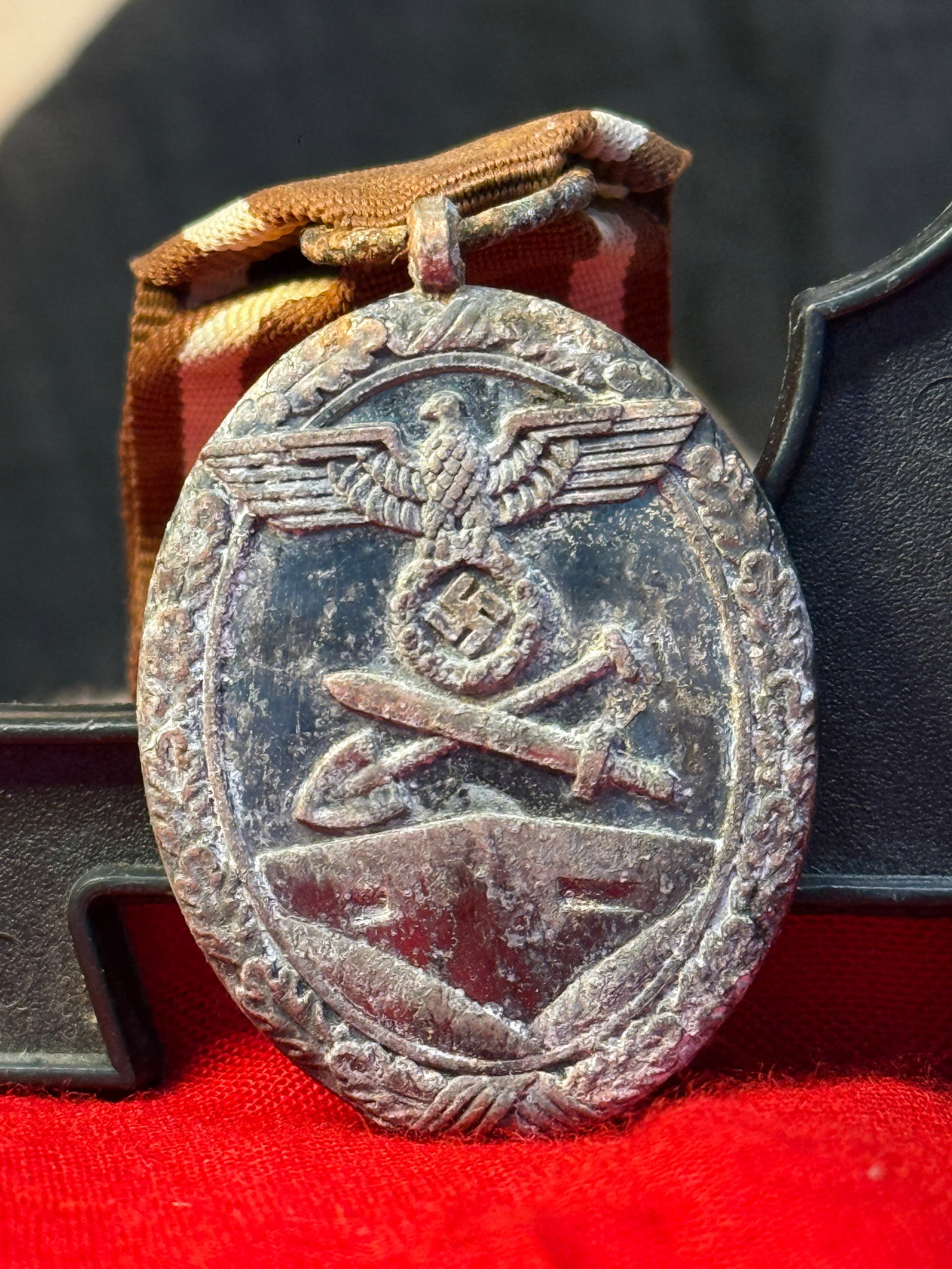 WWII German West Wall Medal (Deutsches Schutzwall-Ehrenzeichen): This bronze-finished medal displays the national eagle above crossed sword and shovel on the obverse, symbolizing military service and labor devoted to construction of the German West Wall defensive f
