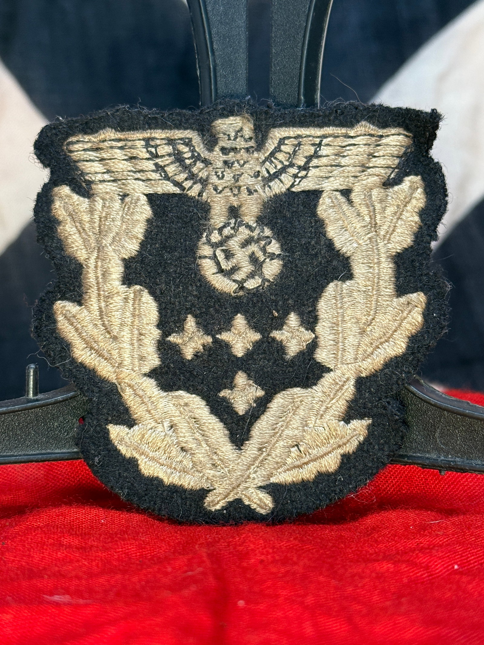 WWII German Waffen-SS Officer Bullion Sleeve Eagle Insignia: This embroidered Waffen-SS officer's sleeve insignia is executed in silver-colored bullion thread on a black wool backing, depicting the SS national eagle above an oak leaf wreath and rank pips. Bulli