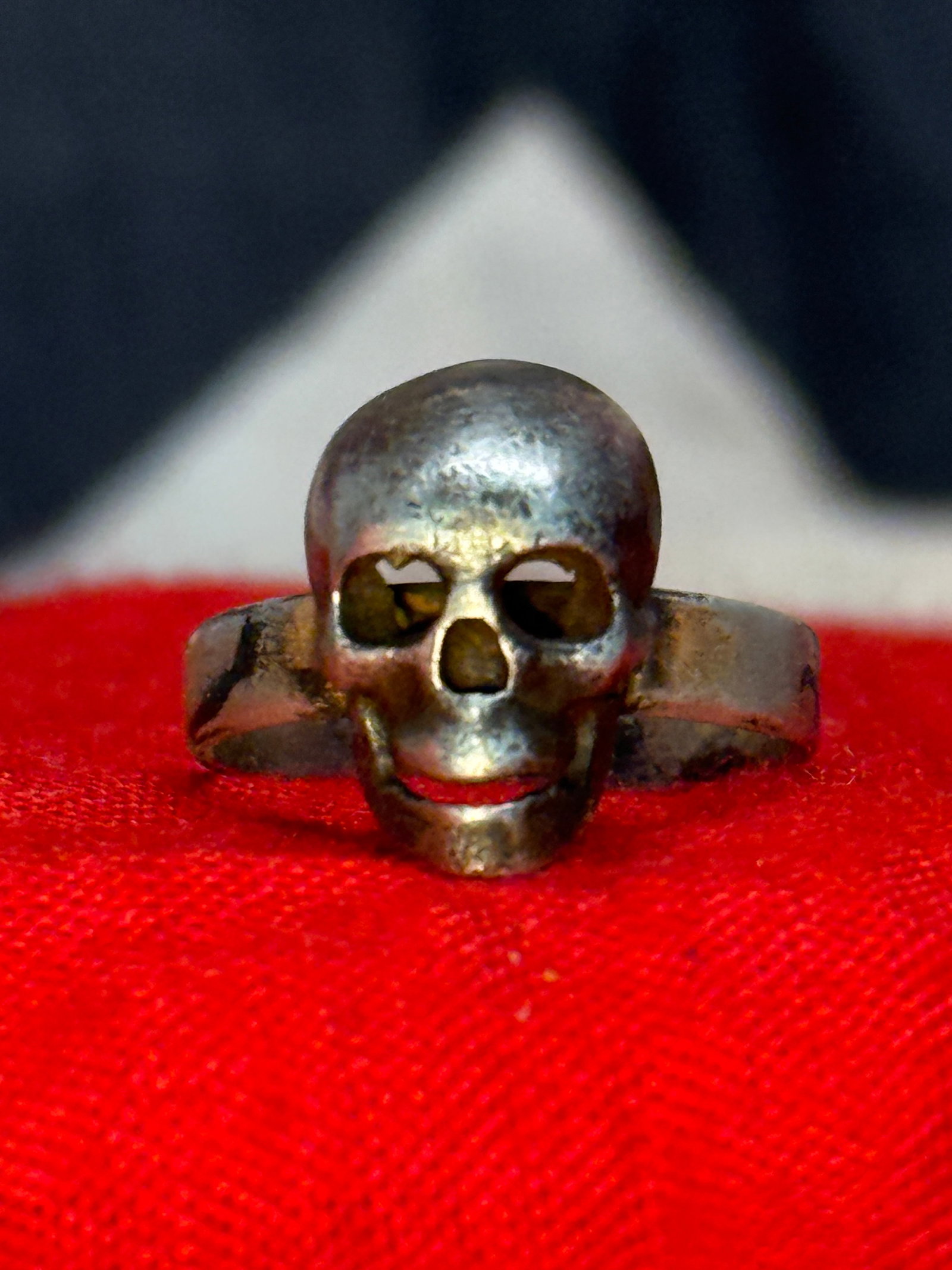 WWII German SS Totenkopf Death Head Silver Skull Ring: This silver ring in the form of a three-dimensional Totenkopf, or death's head, with deeply recessed eye sockets and an open jaw design. The skull motif became one of the most recognizable military em