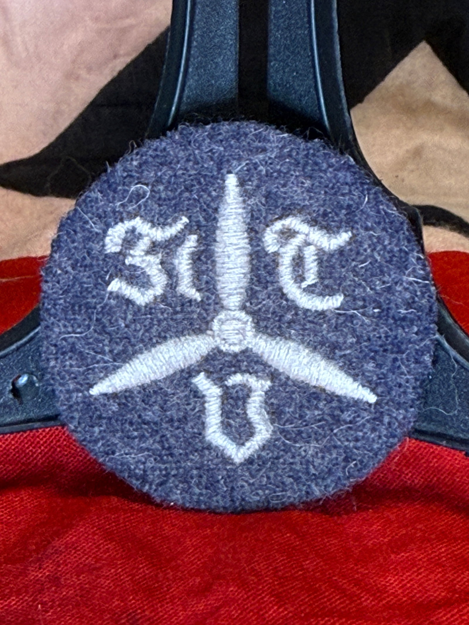 WWII German Luftwaffe Former Military Student Sleeve Insignia: This embroidered circular sleeve insignia features a stylized propeller flanked by Gothic lettering, a design associated with former Luftwaffe military flight students (ehemaliger Fliegerschüler). Wo