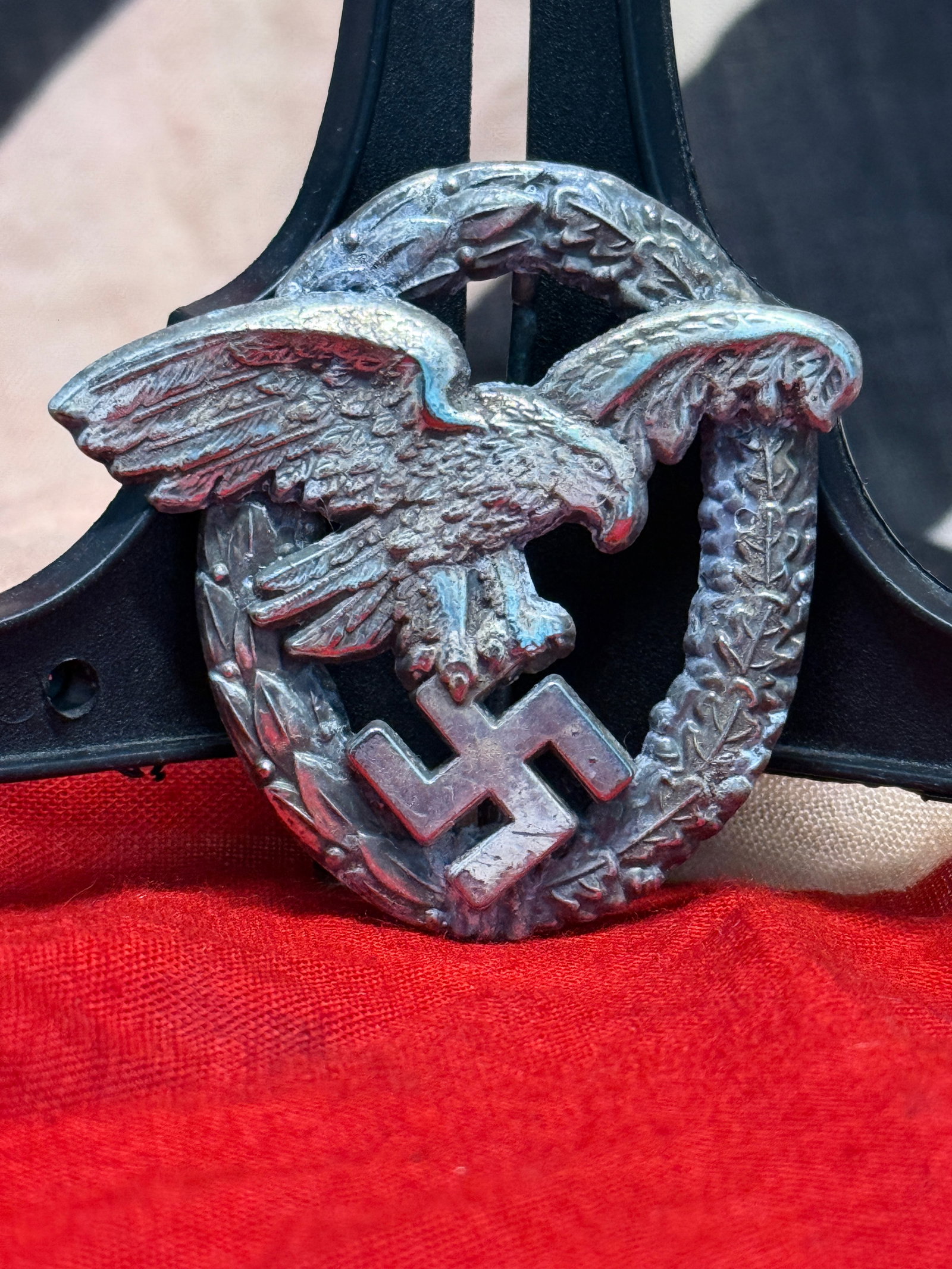 WWII German Deutscher Luftsportverband (DLV) Membership Badge: This circular pinback badge features the emblem of the Deutscher Luftsportverband (DLV), Germany's National Air Sports Association, displaying a stylized white winged propeller within a red center and