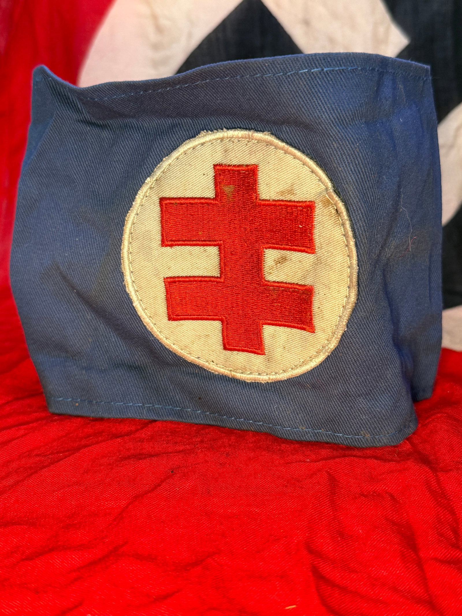 WWII German Red Cross (Deutsches Rotes Kreuz) Medical Armband: This blue cotton armband displays a white circular field bearing the distinctive red cross emblem used by the Deutsches Rotes Kreuz (German Red Cross) during the Second World War. Worn by medical pers