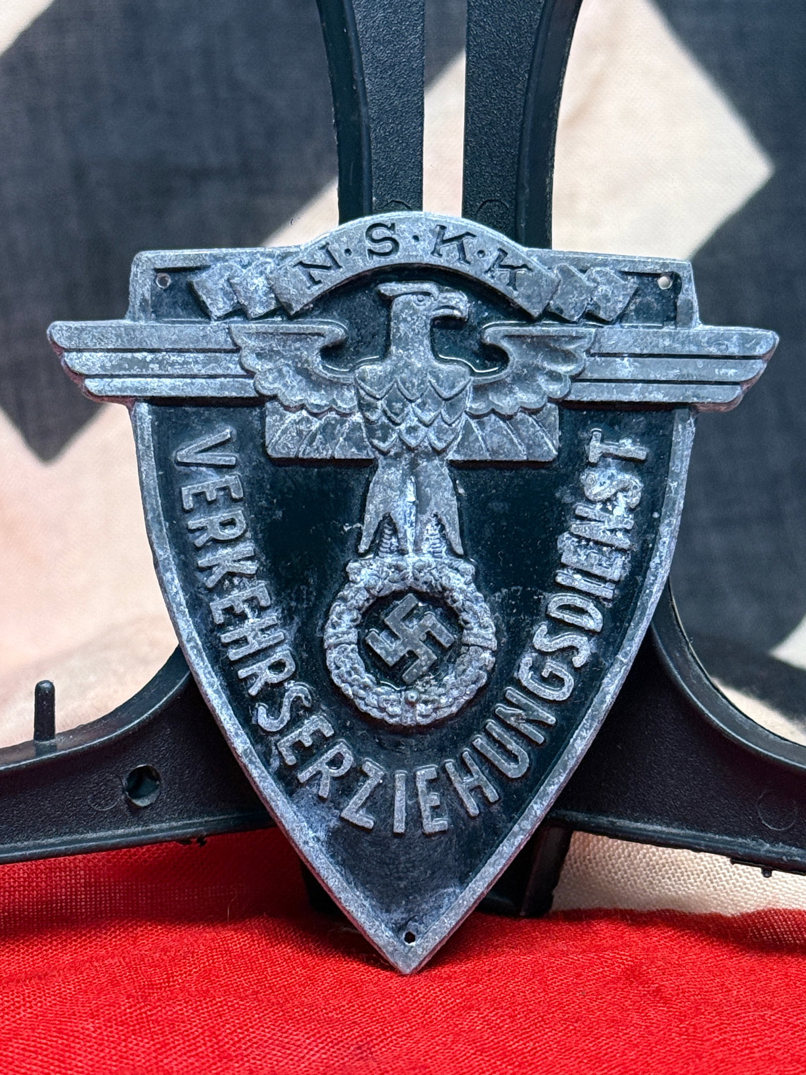 WWII German NSKK Verkehrserziehung (Traffic Education) Wall Plaque: This shield-shaped cast metal plaque bears the initials N.S.K.K. (Nationalsozialistisches Kraftfahrkorps) above the German word "Verkehrserziehung" ("Traffic Education"), surrounding the national eagl