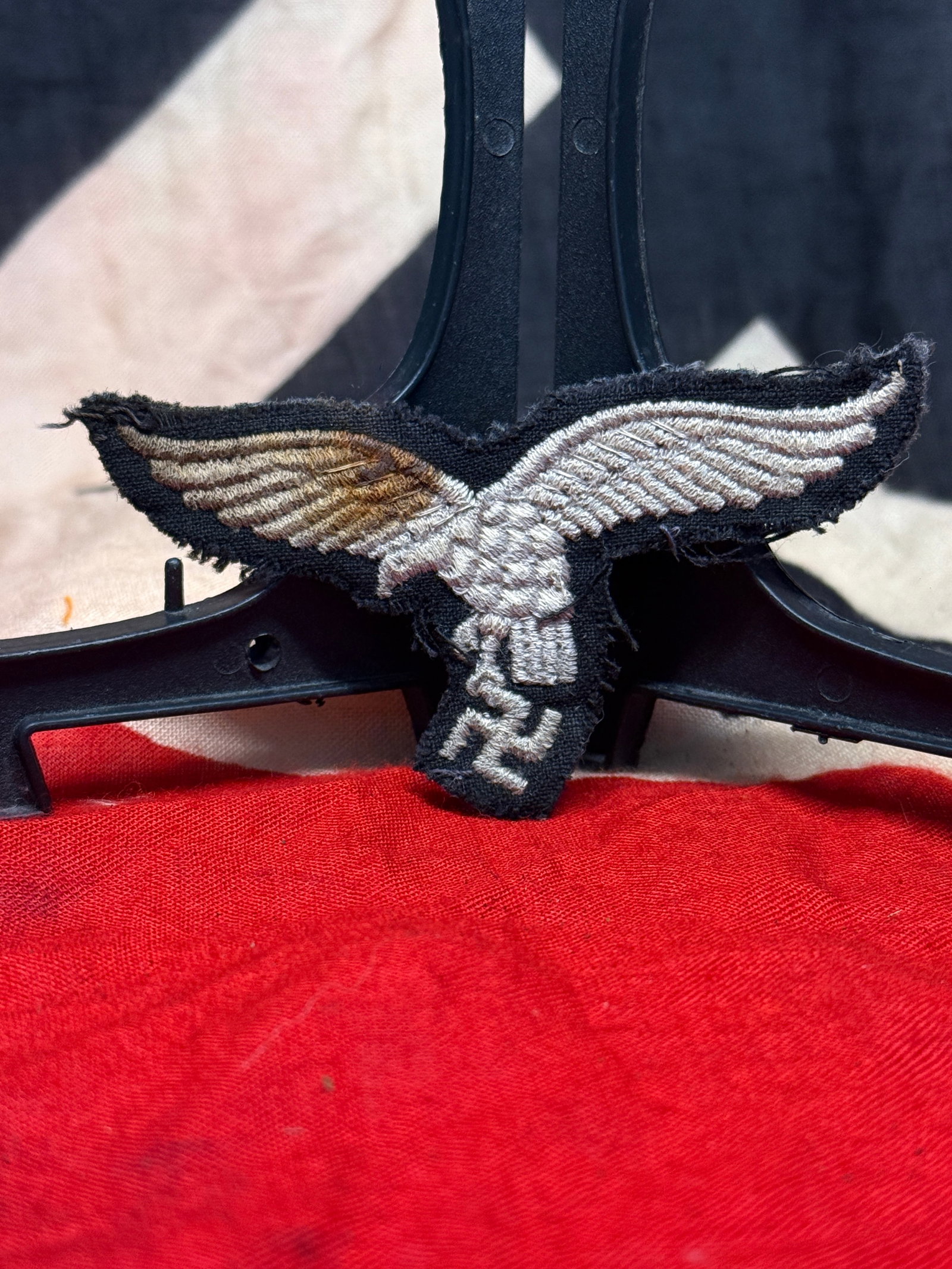 WWII German Luftwaffe Breast Eagle Uniform Insignia: This embroidered Luftwaffe breast eagle features the national eagle clutching a swastika, worked in silver-gray thread on a dark blue wool backing. Intended for wear on Luftwaffe uniforms, the insigni