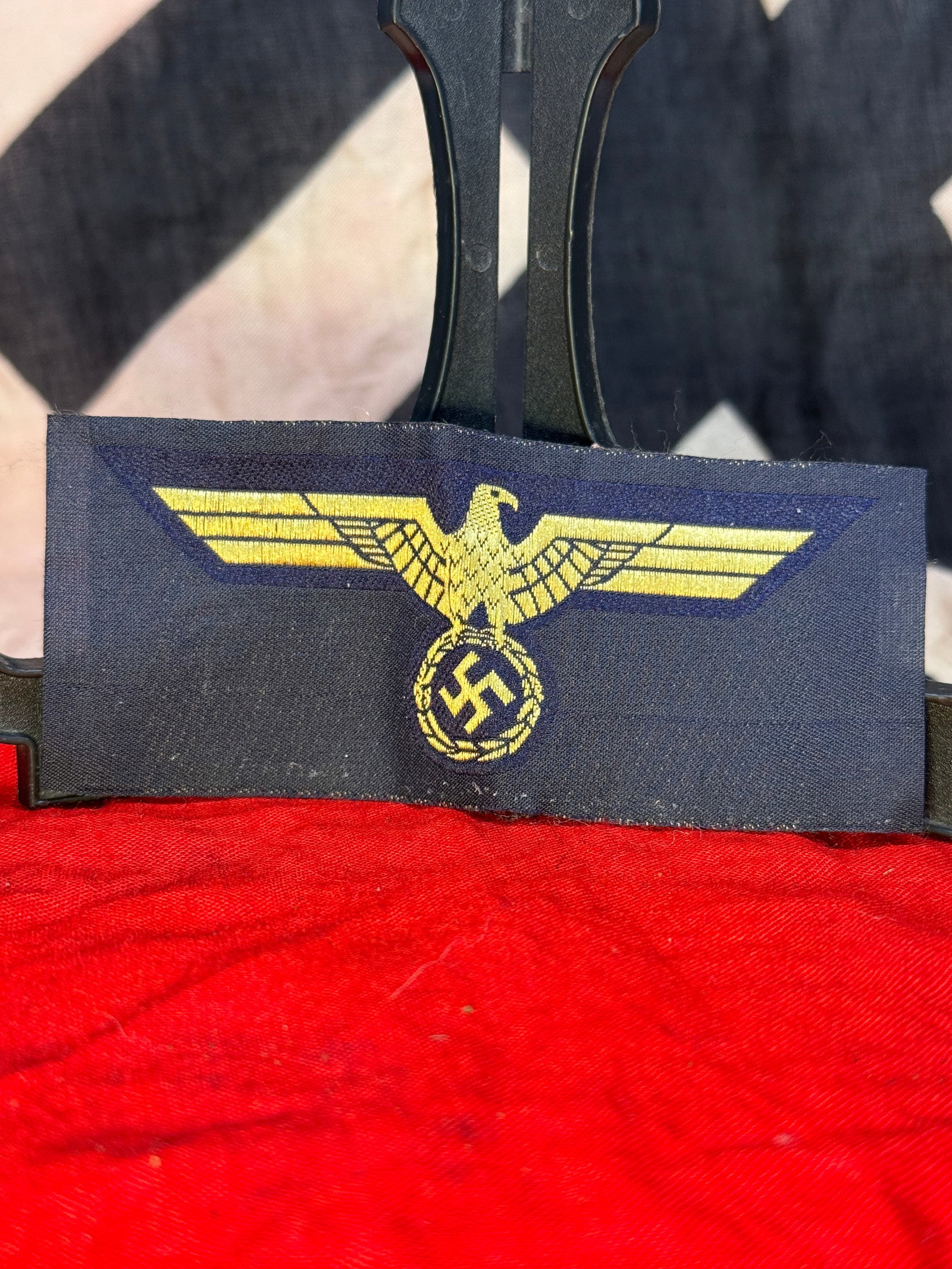 WWII German Kriegsmarine Printed Breast Eagle Insignia: This printed Kriegsmarine breast eagle depicts the national eagle above a wreath enclosing the swastika, printed in gold-colored ink on a dark blue cloth backing. Intended for application to German na