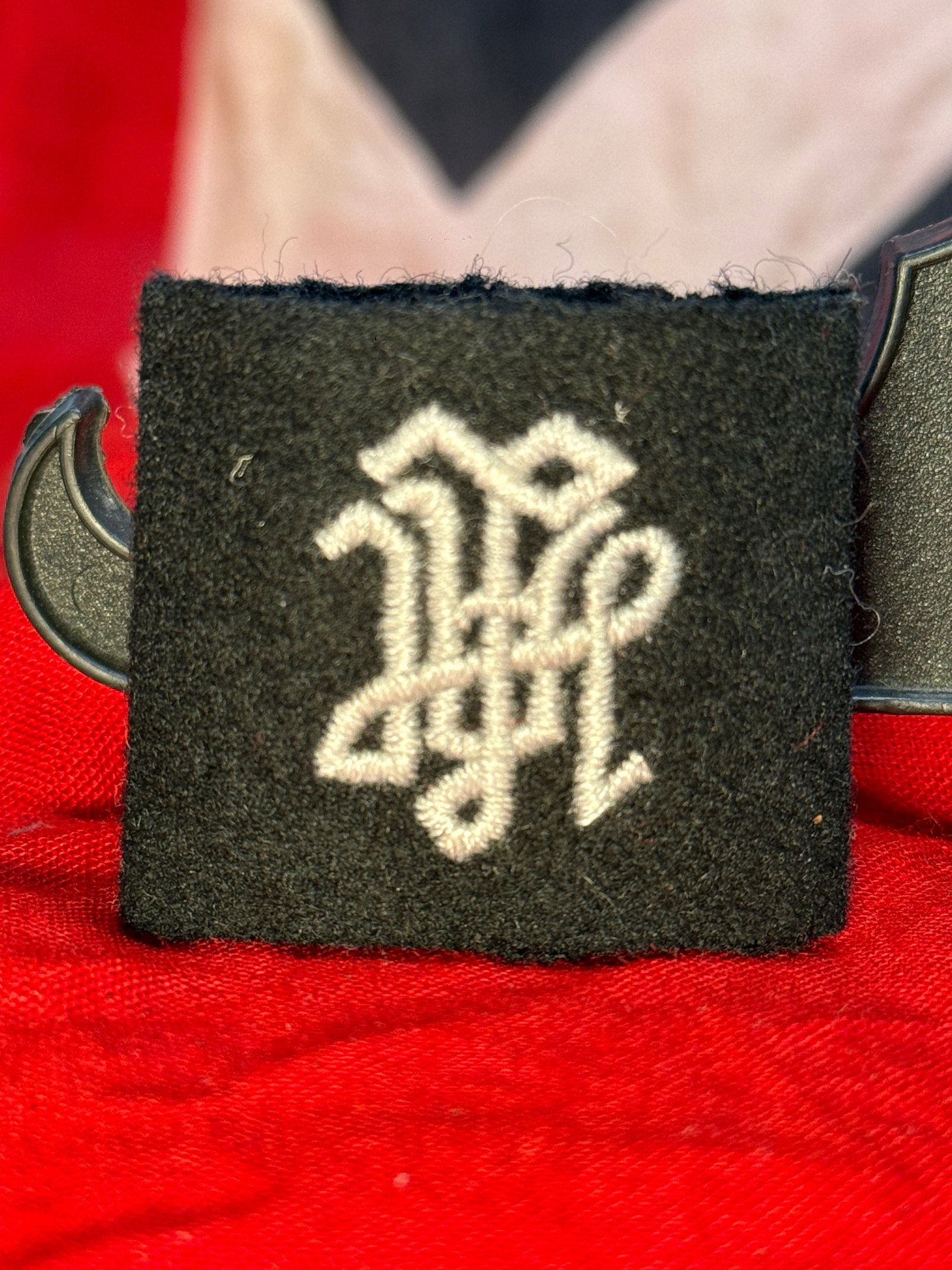 WWII German Waffen-SS "LAH" Slip-On Shoulder Board Cypher: This embroidered insignia features the intertwined Gothic "LAH" monogram representing the Leibstandarte SS Adolf Hitler (LAH), executed in white thread on a black wool slip-on backing. Designed for we