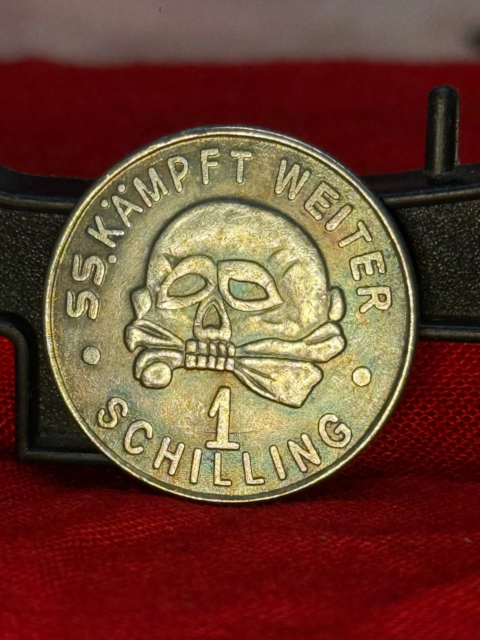 WWII German SS "Kämpft Weiter – 1 Schilling" War Donation Token: This aluminum token features the SS Totenkopf (death's head) above the inscription "SS. KÄMPFT WEITER" ("SS Keep Fighting") and the denomination "1 Schilling." The reverse bears the SS runes with the