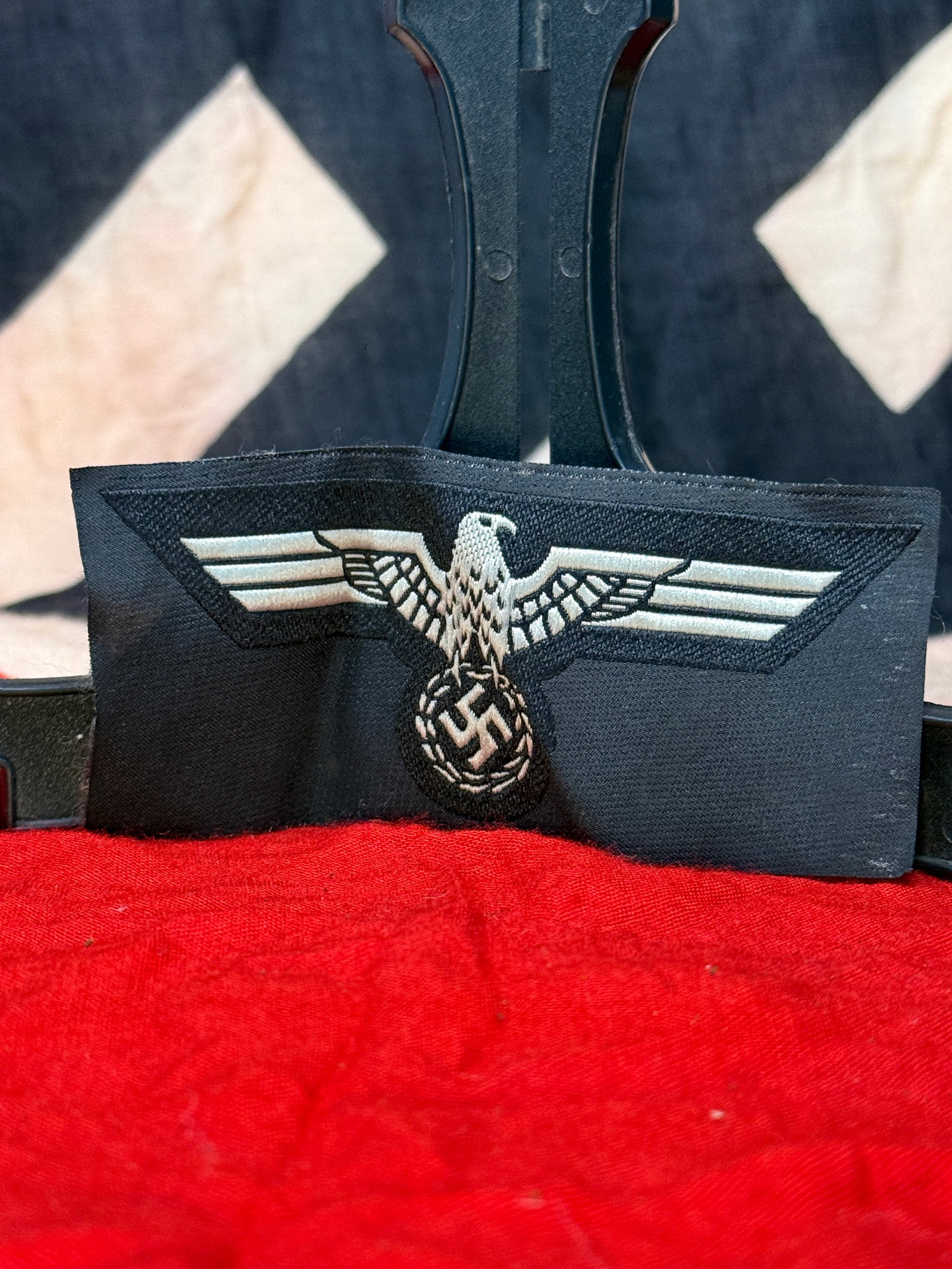WWII German Panzer Breast Eagle Insignia – Silver Embroidered Eagle on Black: WWII German Panzer breast eagle insignia featuring a spread-wing eagle clutching a wreathed swastika, executed in silver-colored embroidered thread against a black cloth backing. The black field is ch