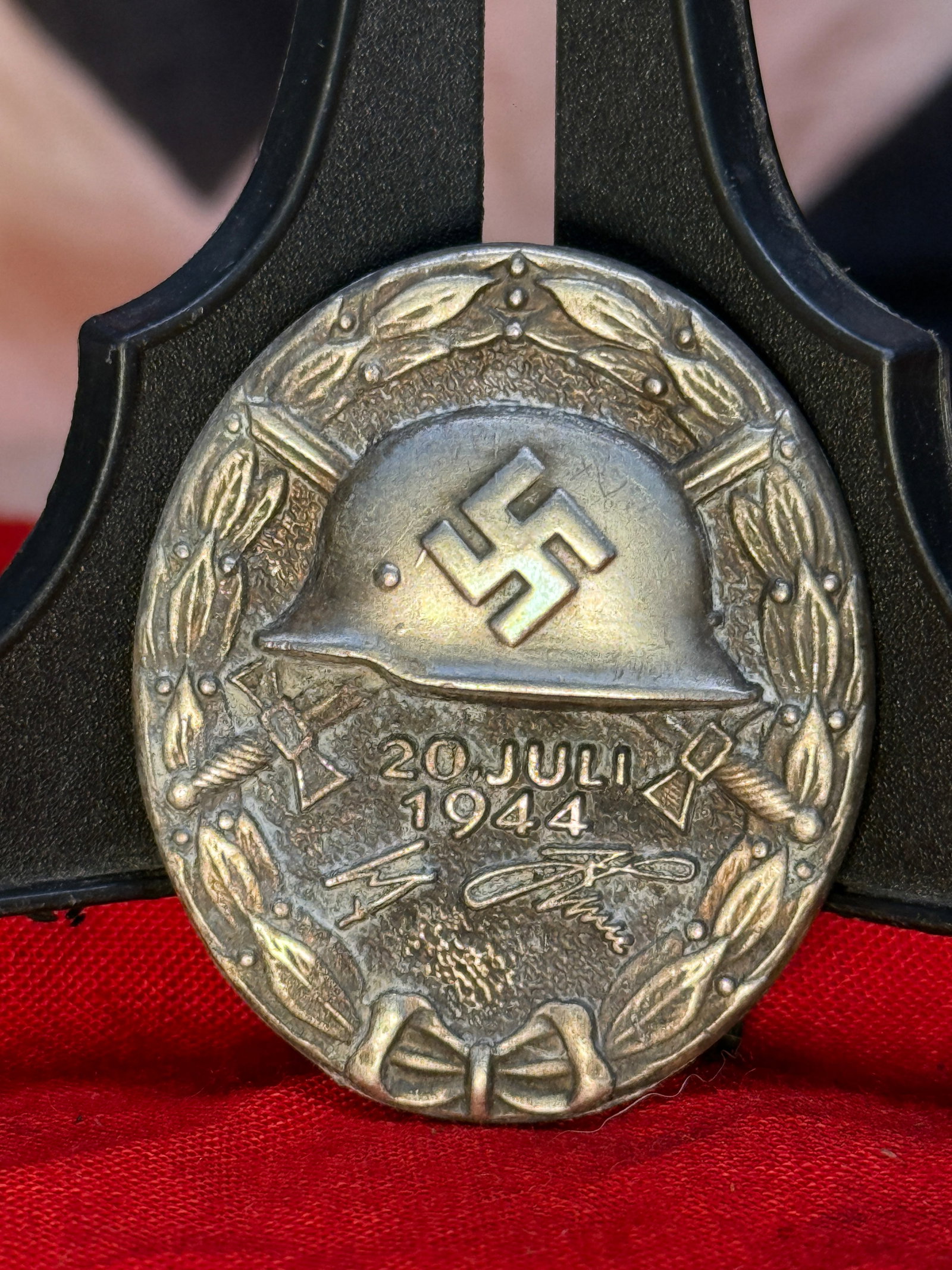 WWII German 20 July 1944 800 Silver Wound Badge: This 800 silver circular badge depicts a German steel helmet bearing a swastika above the inscription "20 JULI 1944" with Adolf Hitler's facsimile signature below, all enclosed within a laurel wreath.