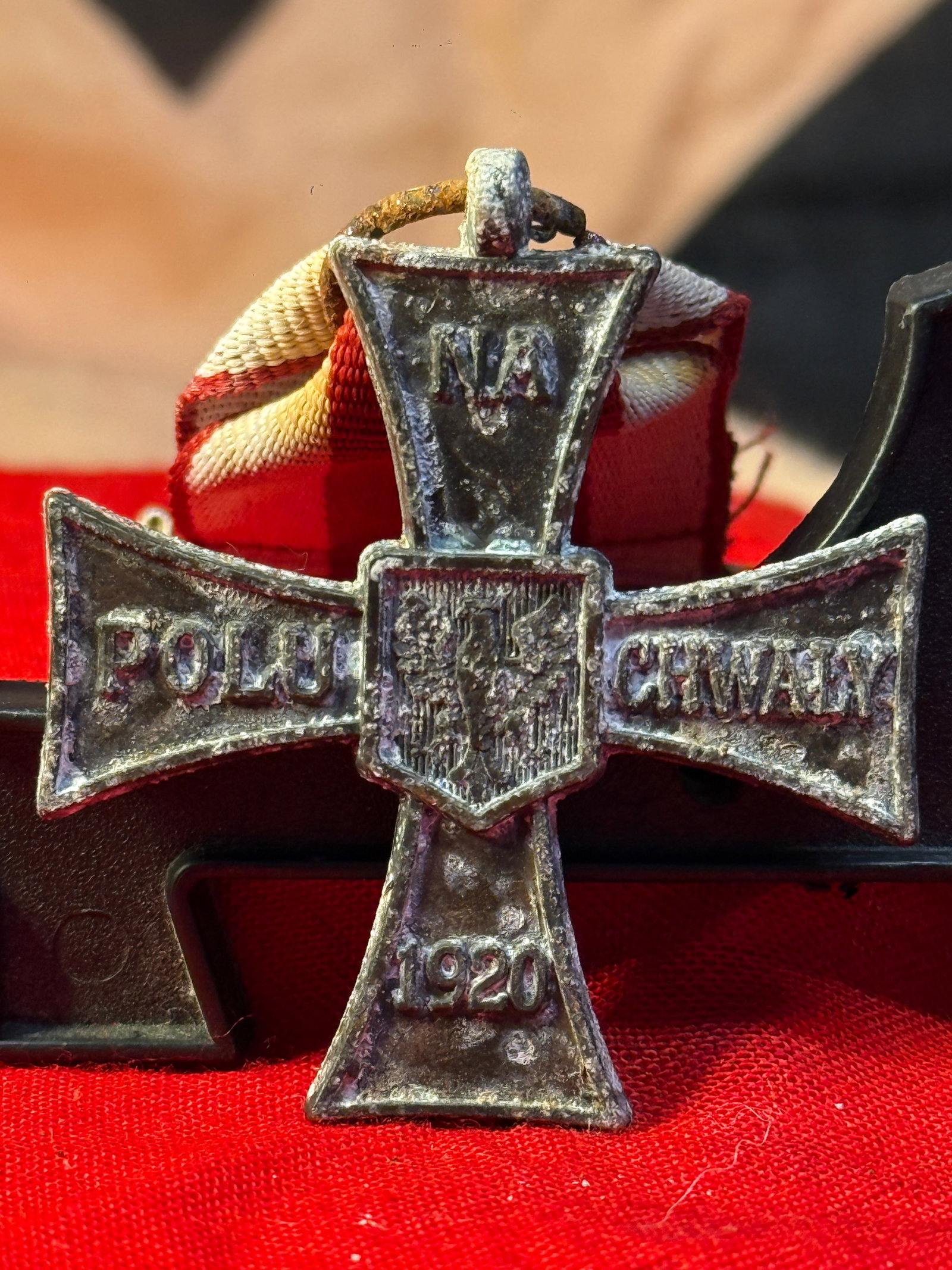 Polish "Polu Human..." Commemorative Cross Medal: This silvered cross-shaped commemorative medal bears the inscription "POLU HUMAN..." across the horizontal arms with "1920" on the lower arm and a Polish eagle shield at the center beneath the letters