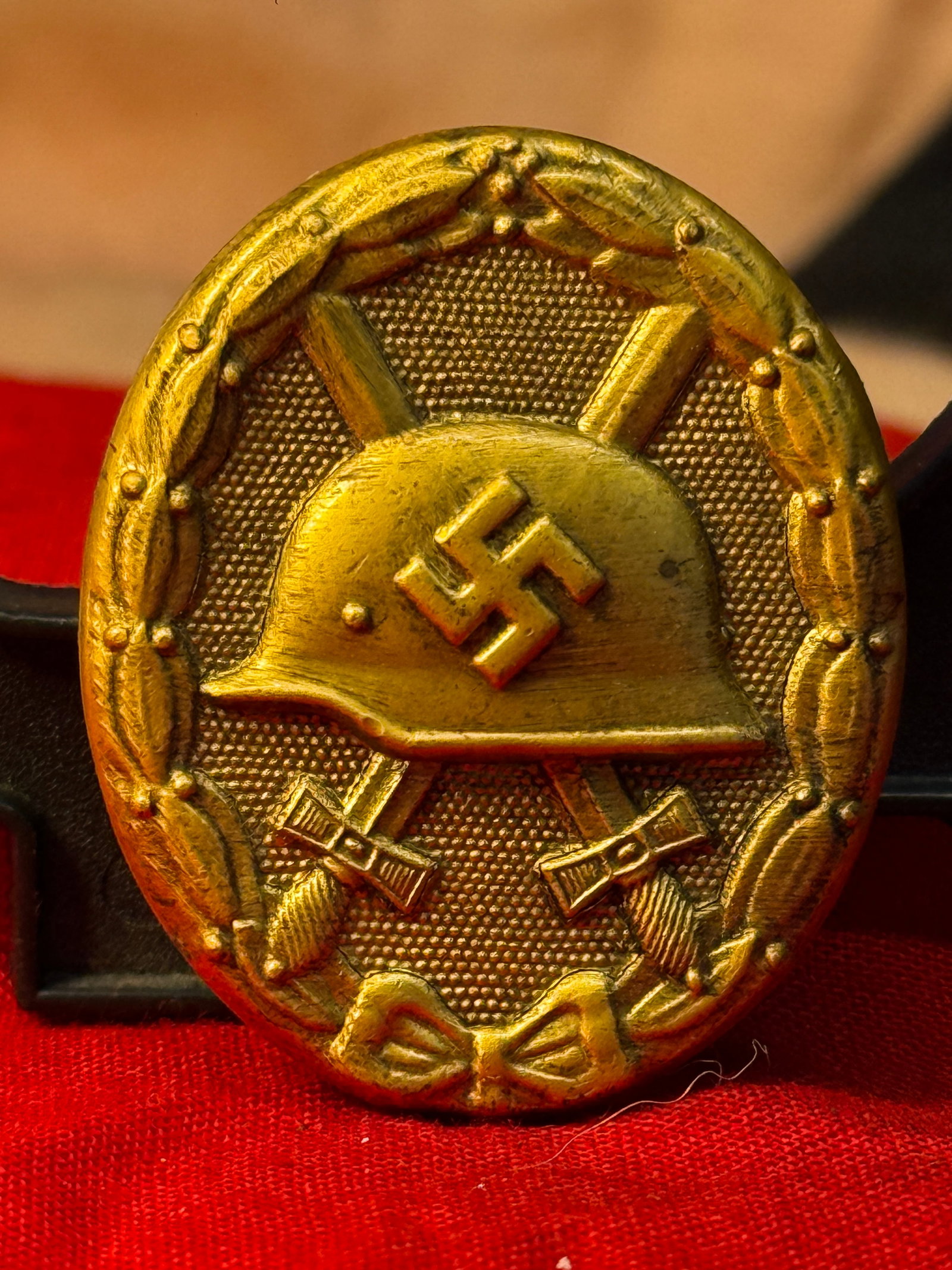 WWII German Wound Badge in Gold Marked 30: This oval gilt-finished badge features a German steel helmet bearing a swastika over crossed swords, all surrounded by a detailed laurel wreath. The reverse retains its original vertical pin assembly 
