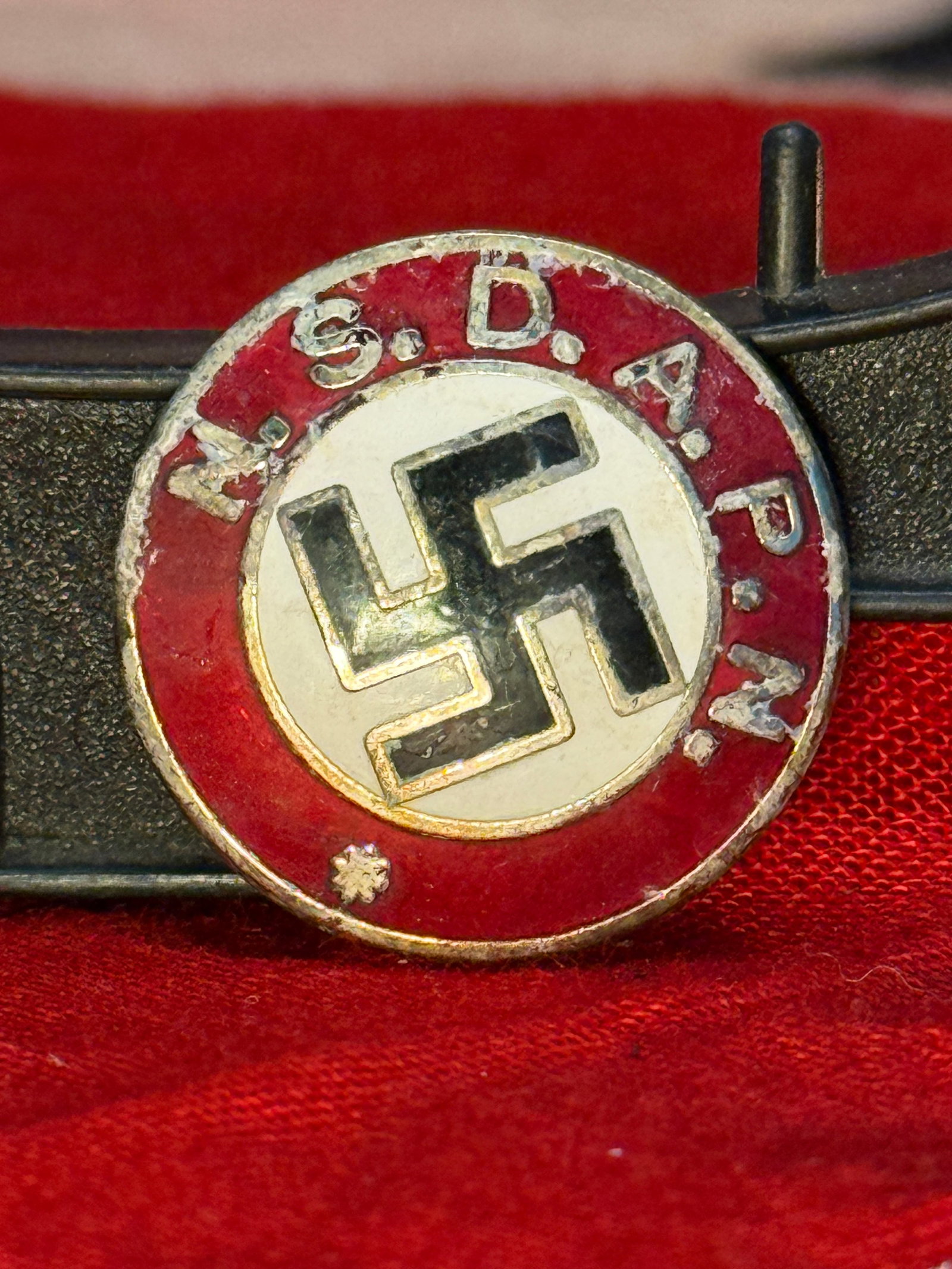 WWII German NSDAP Party Membership Badge By RZM M1/129: This circular enameled badge features the initials "N.S.D.A.P." surrounding a black swastika on a white field with a red enamel border. The reverse retains its original horizontal pin assembly, is ser