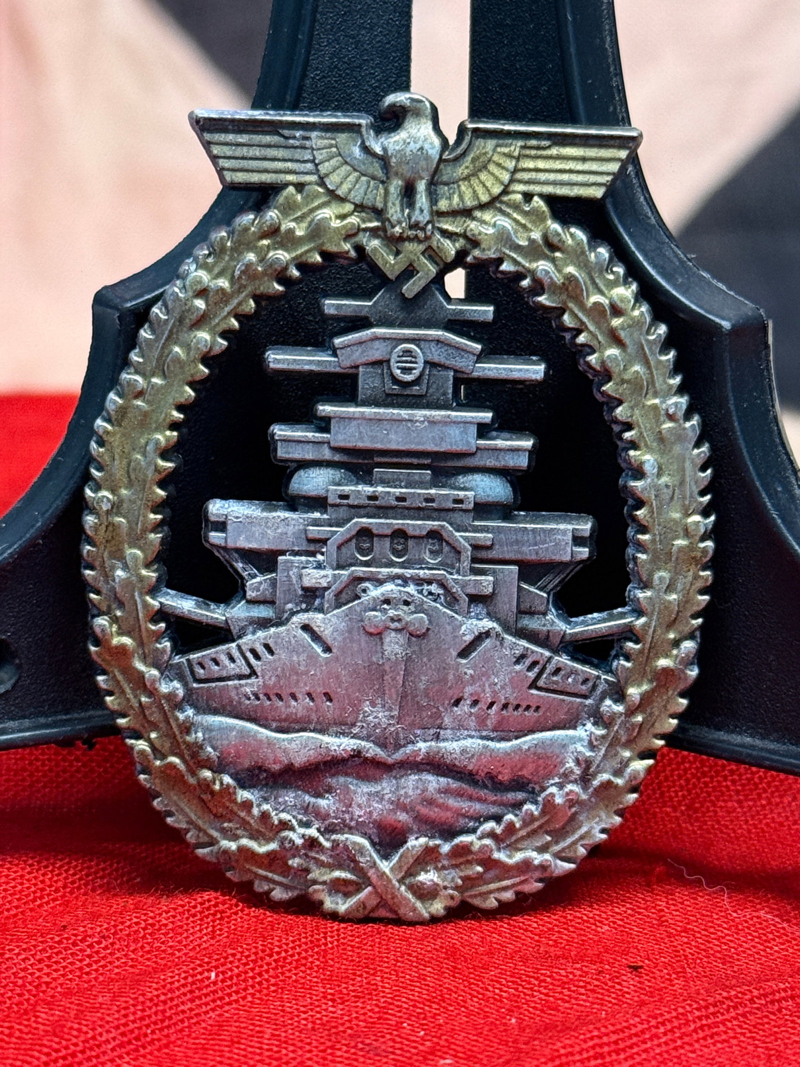 WWII German Kriegsmarine High Seas Fleet Badge - Maker Marked: This silver-toned naval combat badge depicts a German battleship cutting through heavy seas beneath the national eagle and swastika, all enclosed within an oak leaf wreath. The reverse retains its ori