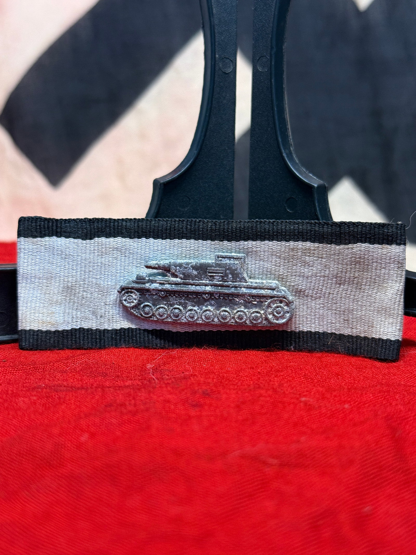 WWII German Panzer Tank Ribbon Bar Device: This WWII German Panzer tank ribbon bar device consists of a detailed miniature tank mounted to a black, white, and silver-gray ribbon bar intended for wear on the service uniform. Such ribbon bar dev