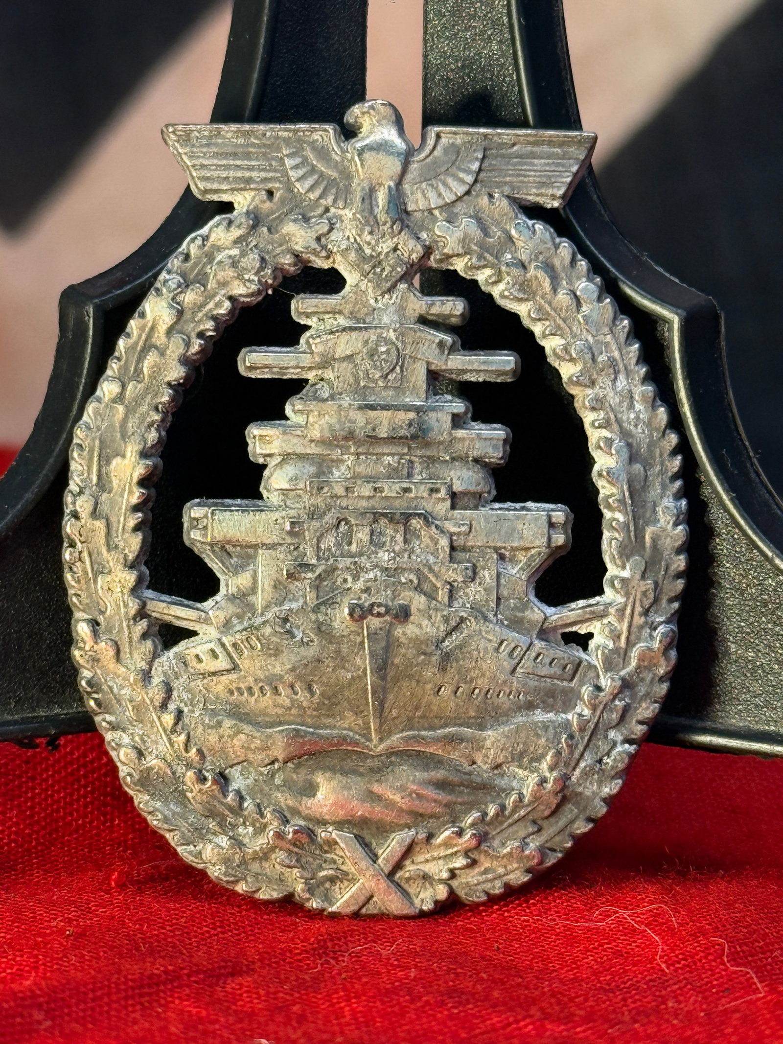 WWII German Kriegsmarine High Seas Fleet Badge By FEC. ADOLF BOCK AUSF. SCHWERIN BERLIN: This WWII German Kriegsmarine High Seas Fleet Badge features a detailed battleship beneath the national eagle and is surrounded by an oak leaf wreath with crossed naval elements at the base. The rever