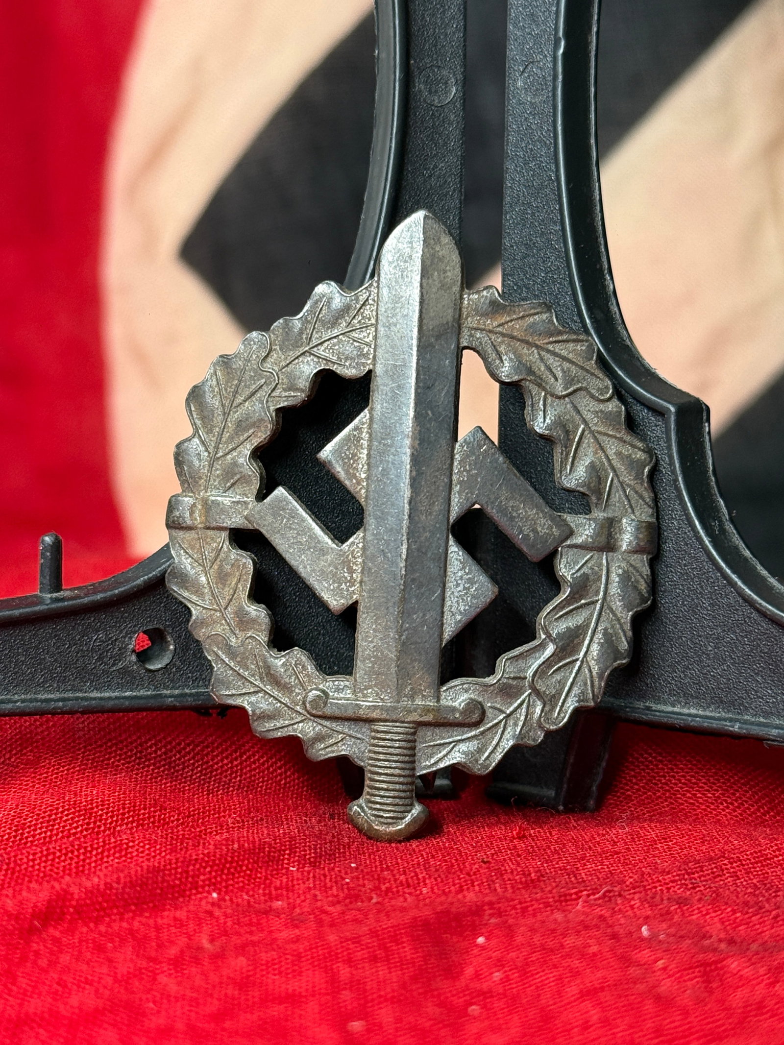 WWII German SA Sports Badge in Bronze: This WWII German SA Sports Badge (SA-Sportabzeichen) features a vertical sword over a swastika enclosed within an oak leaf wreath. The reverse is marked "Eigentum d. Obersten SA-Führung" and "W. Redo