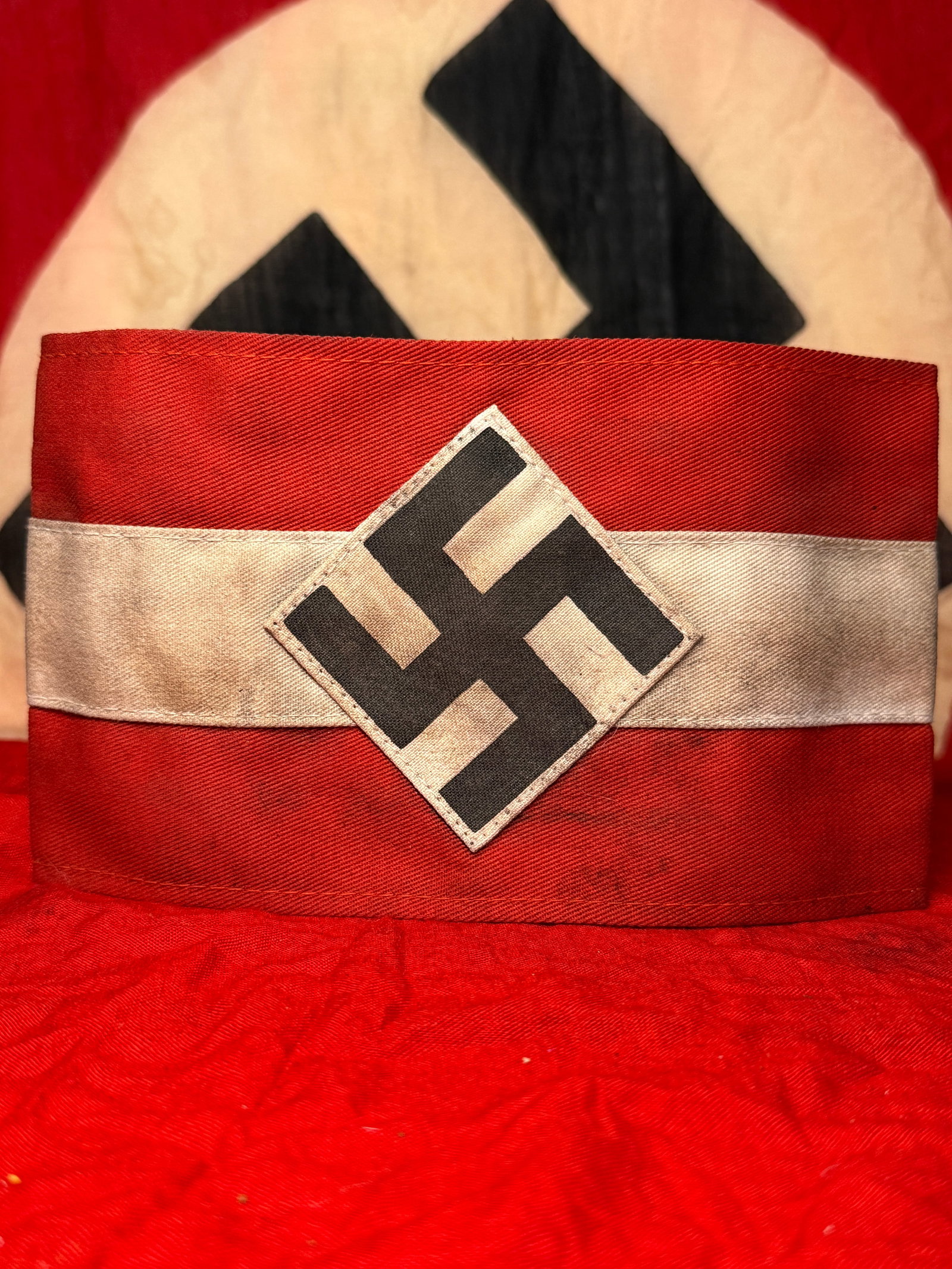 WWII German Hitler Youth (HJ) Leader Armband with RZM Tag: This WWII German Hitler Youth (HJ) Leader armband is constructed of red cloth with a white center stripe and a separately applied diamond bearing the black swastika. The interior retains its original 