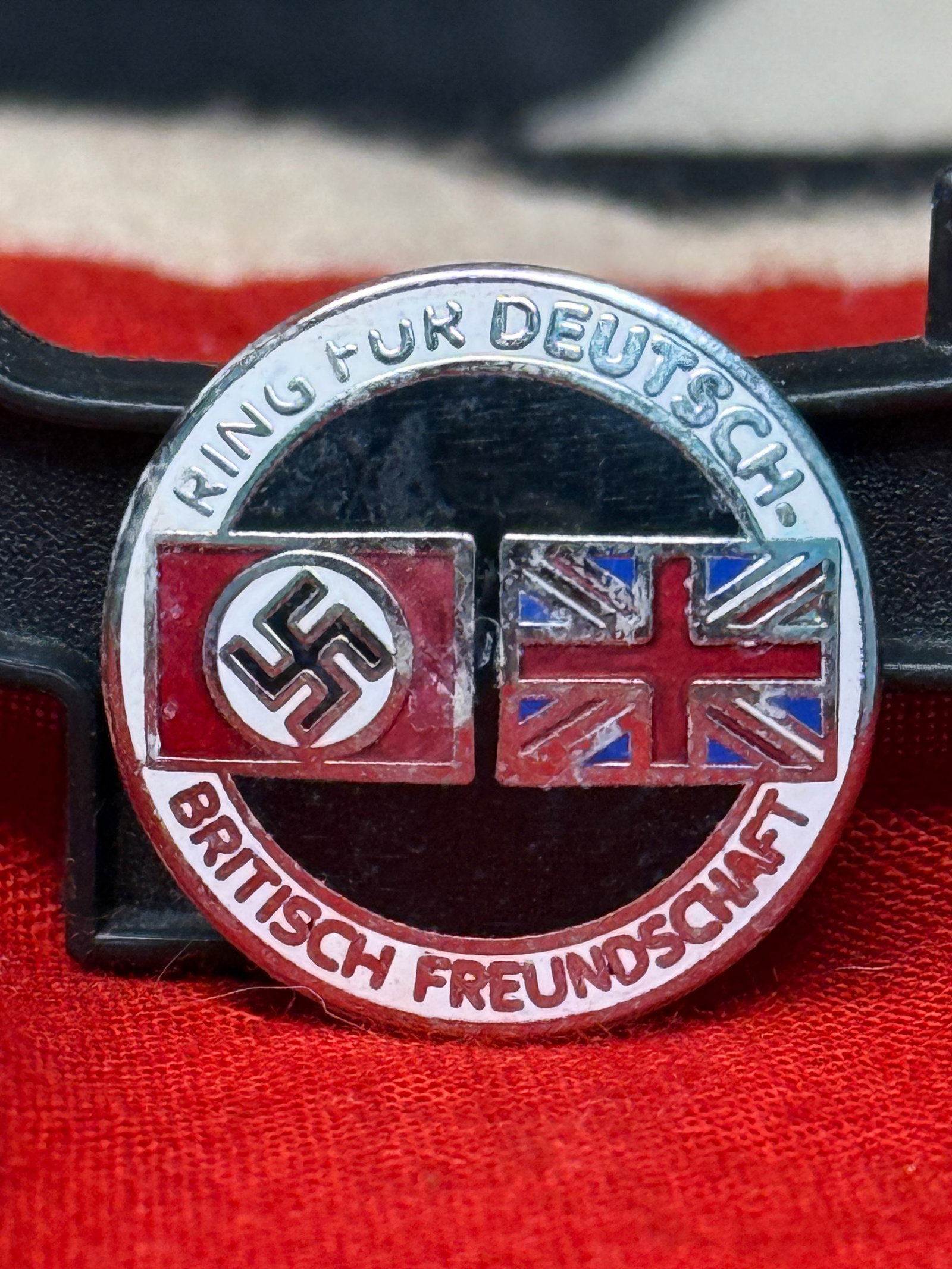 WWII German Anglo-German Friendship "Ring für Deutsch-Britisch Freundschaft" Badge By RZM M1/129: This circular enameled badge displays the German and British national flags beneath the inscription "Ring für Deutsch-Britisch Freundschaft" ("Association for German-British Friendship"), reflecting 
