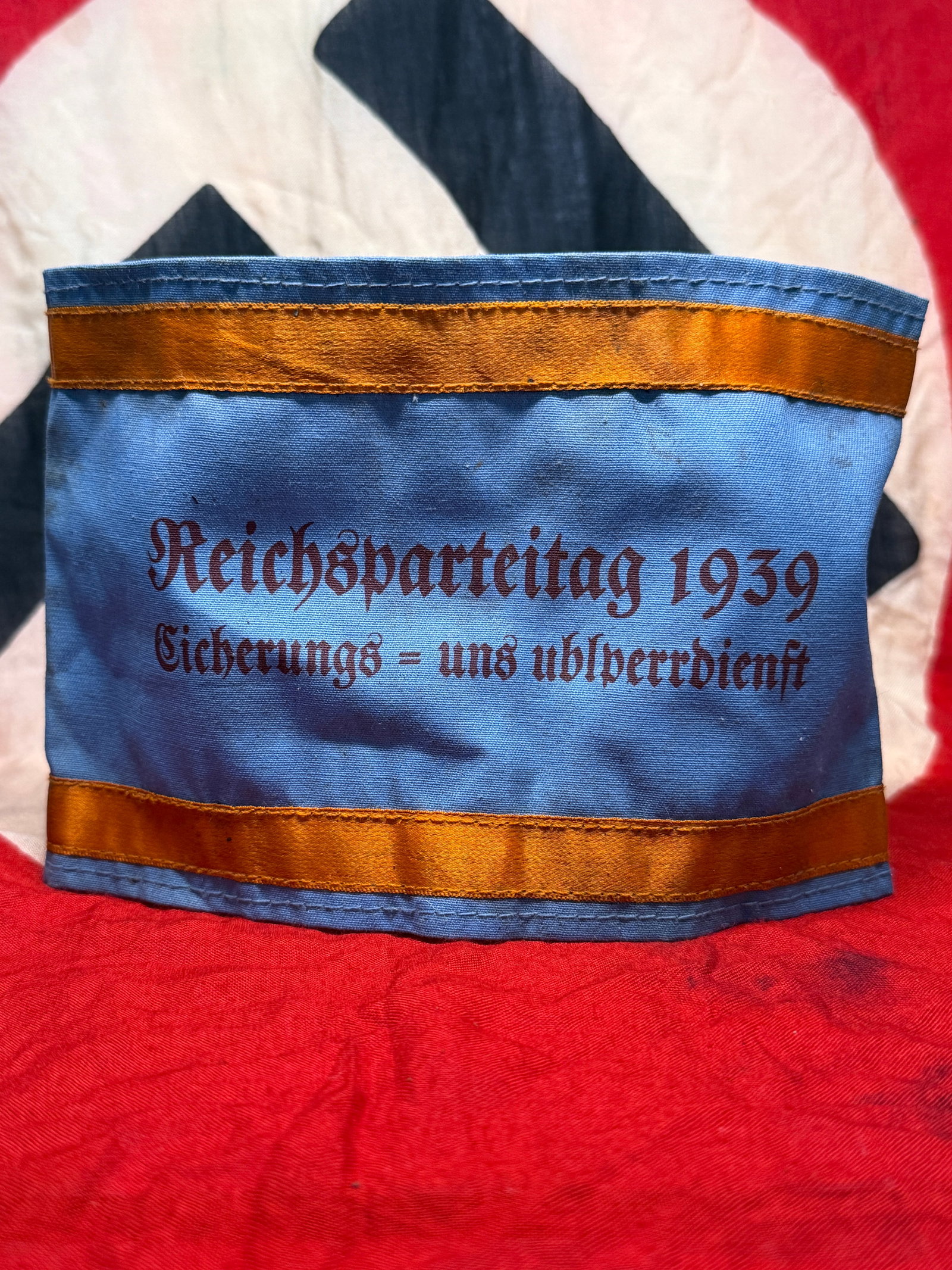 WWII German Reichsparteitag 1939 Security Service Armband: This blue cloth armband bears the inscription "Reichsparteitag 1939 Sicherungs- und Absperrdienst," identifying it as an armband issued for personnel assigned to security and crowd control duties duri