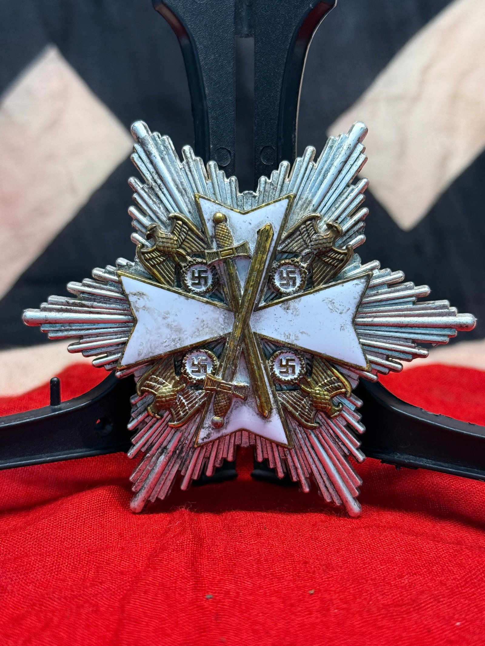 WWII German War Merit Cross First Class with Swords Star: This striking star-shaped breast badge incorporates a white enameled Maltese cross over a radiating silver starburst with crossed swords and Wehrmacht eagles surrounding the central design. The revers