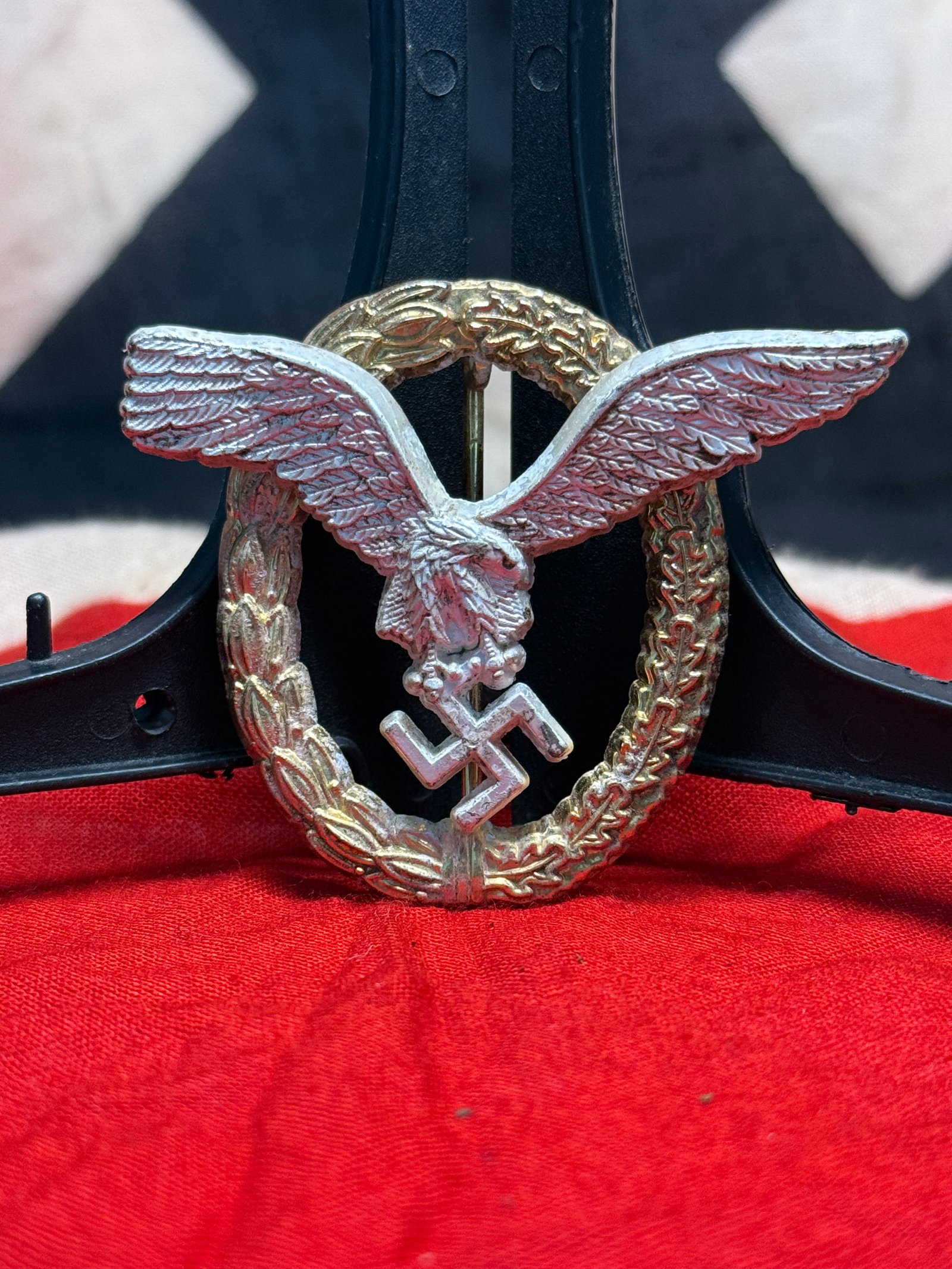 WWII German Luftwaffe Pilot Badge By Assmann: This WWII German Luftwaffe Pilot Badge features the iconic silver eagle in flight clutching a swastika, mounted upon an oval wreath of oak and laurel leaves. The reverse retains its original vertical 