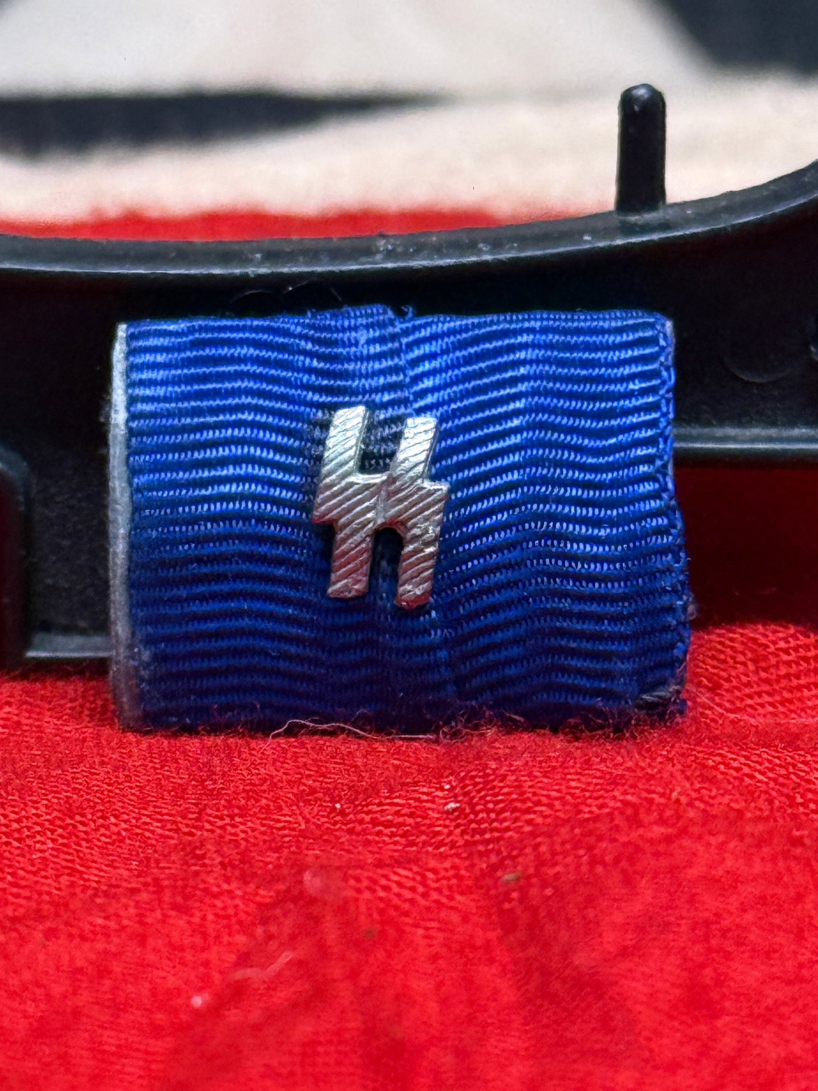 WWII German SS 12-Year Long Service Ribbon Bar: This WWII German SS 12-Year Long Service Ribbon Bar consists of the characteristic blue ribbon mounted on a metal backing and fitted with silver SS runes at the center. The reverse retains its origina