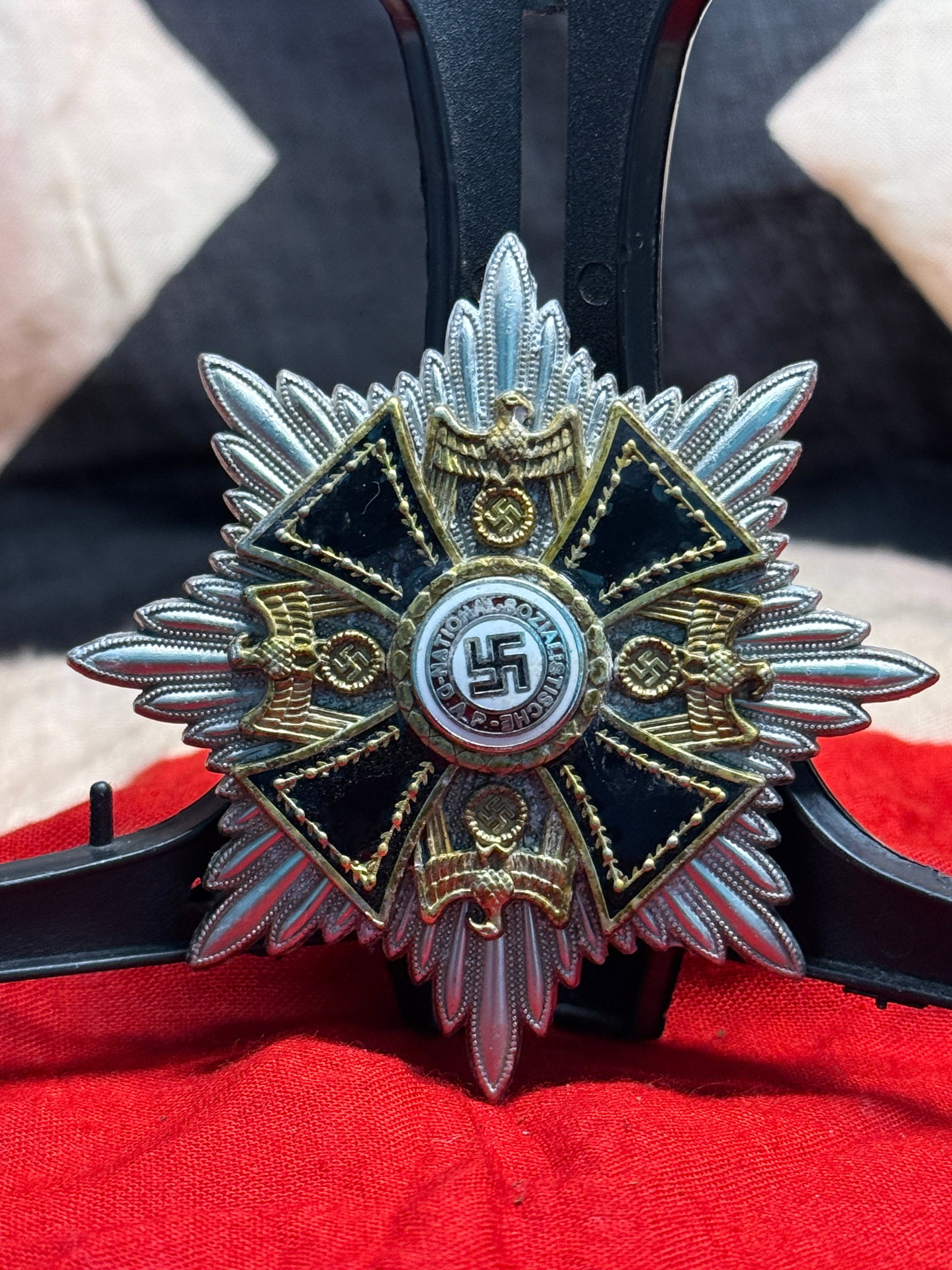 WWII German Order of the German Eagle Breast Star: This WWII German Order of the German Eagle Breast Star features a silver multi-rayed star supporting a black enameled cross with gilt national eagles between the arms and a central medallion bearing t