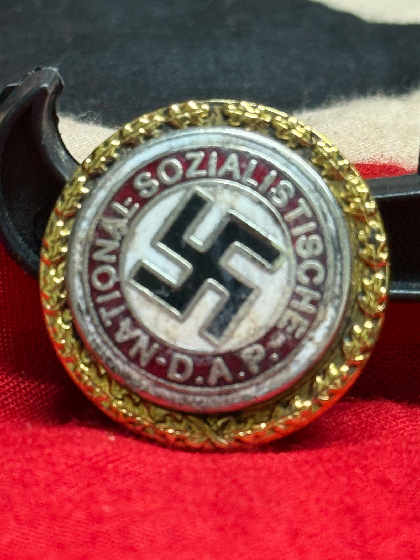 WWII German NSDAP Gold Party Badge By Ges. Gesch. Serial No 50569: This circular National Socialist German Workers' Party (NSDAP) Gold Party Badge features the party emblem surrounded by the inscription "National-Sozialistische D.A.P." and retains its reverse pin ass