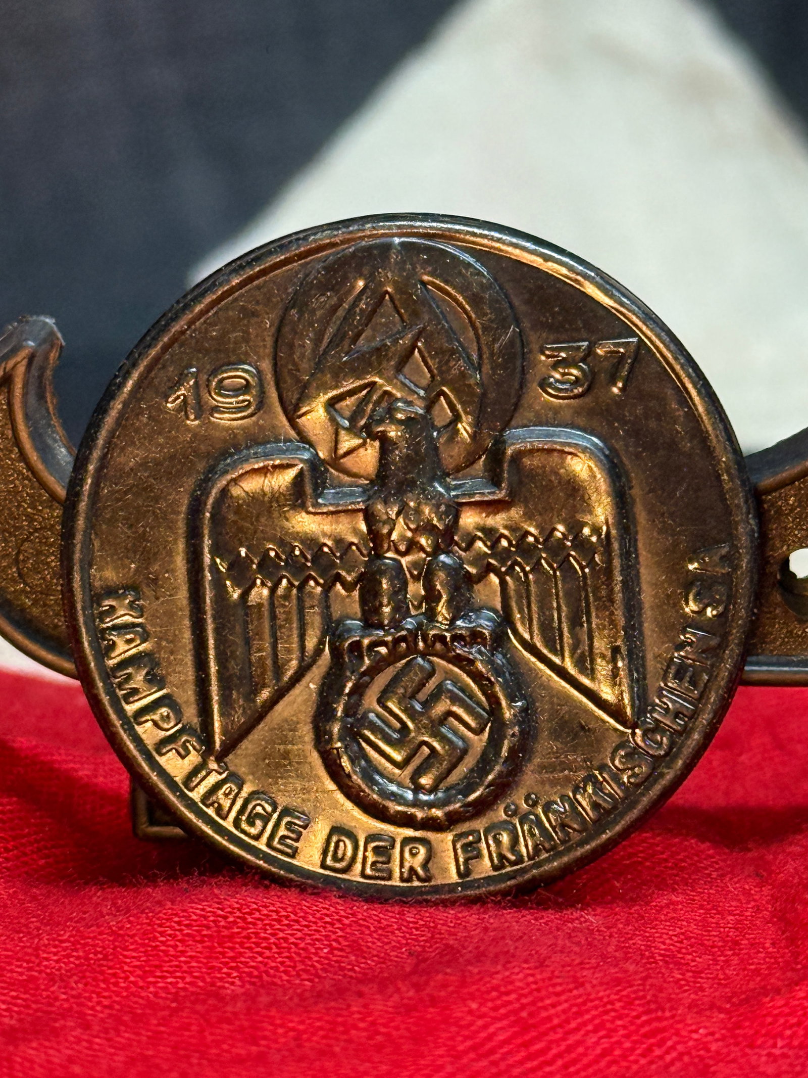 WWII German NSDAP "Heim ins Reich" Political Supporter's Lapel Pin: This circular enameled lapel pin displays the inscription "HEIM INS REICH" surrounding a white field with a red swastika at the center. The reverse is stamped "GW" and retains its original pin assembl