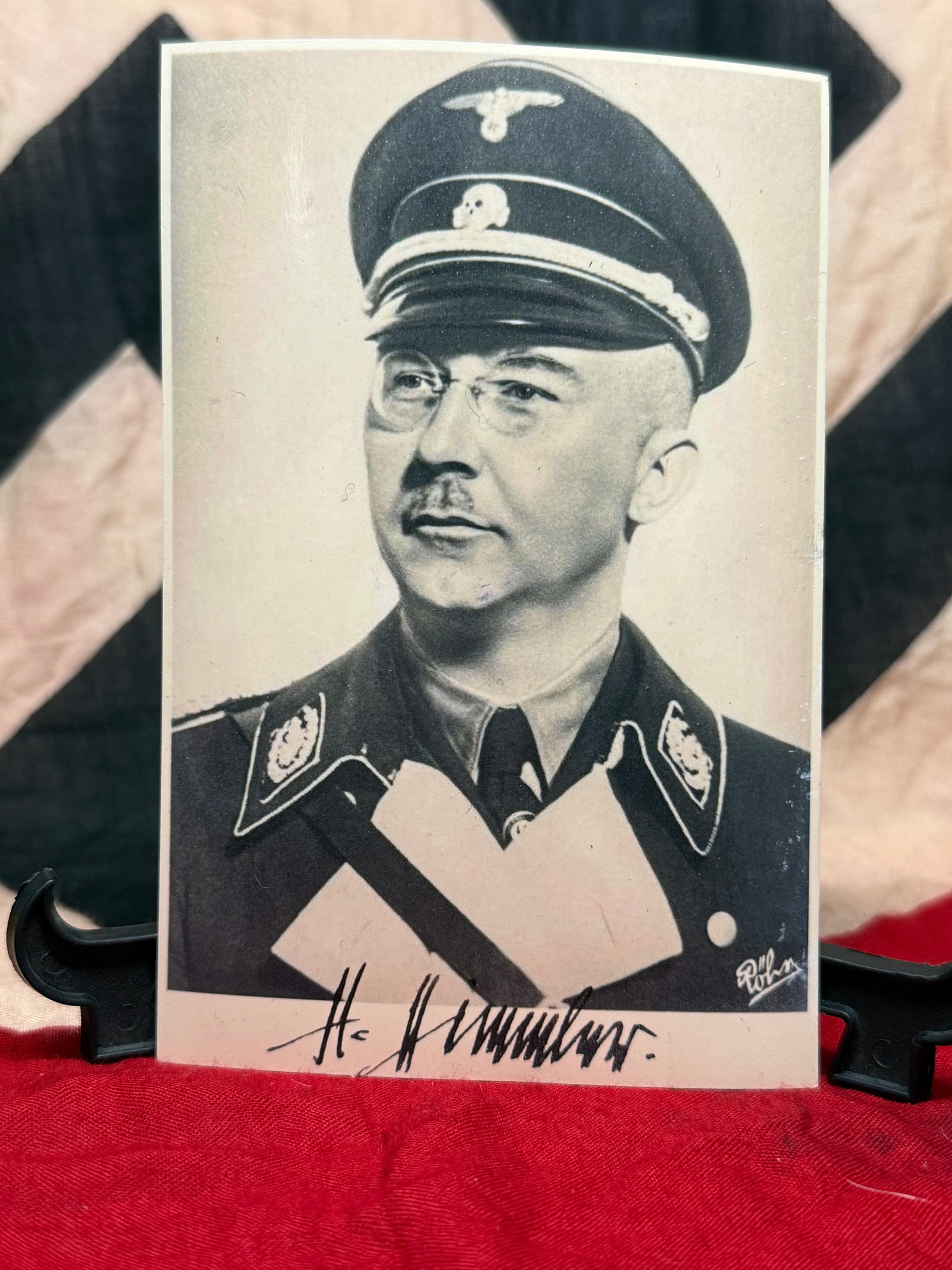 WWII German Heinrich Himmler Portrait Photograph with Signature: This black-and-white portrait depicts Heinrich Himmler wearing his SS uniform and visor cap, with a signature appearing beneath the image. The reverse remains largely blank aside from faint transfer m