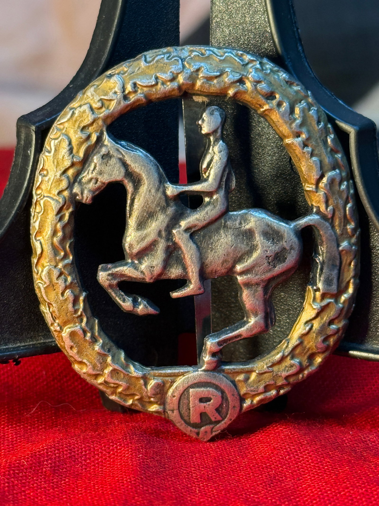 WWII German SA Equestrian Sports Achievement Badge: This openwork oval badge depicts a mounted rider within an oak leaf wreath above the letter "R." The reverse is marked "1. CHR. LAUER NÜRNBERG," "GES. GESCH.," and "GESETZLICH GESCHÜTZT," while reta