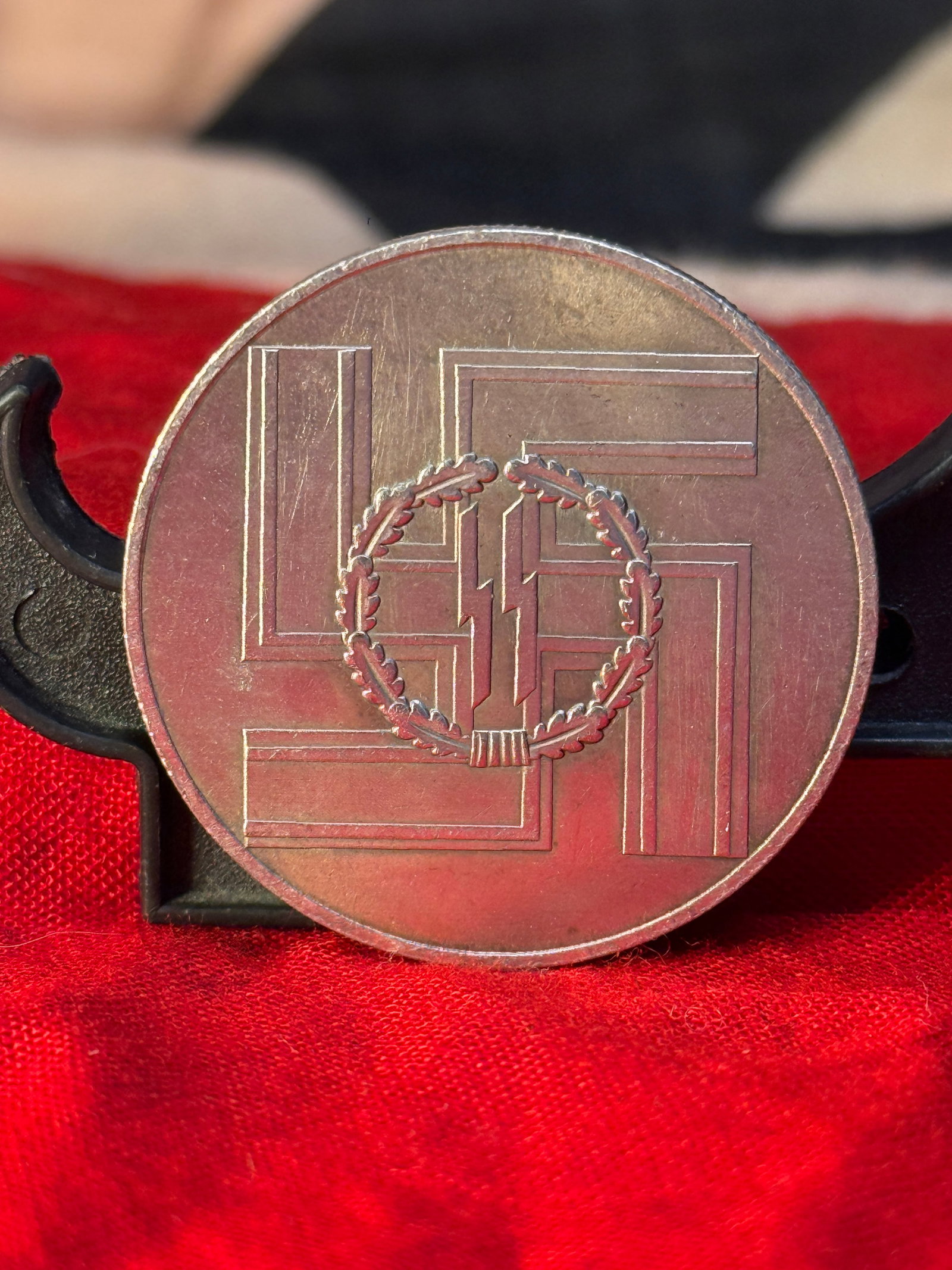 WWII German SS "Für Treue Dienste in der SS" Commemorative Medal: This circular silver-toned medal displays a large swastika enclosing the SS runes within an oak leaf wreath on the obverse, while the reverse is inscribed "Für Treue Dienste in der SS" ("For Faithful