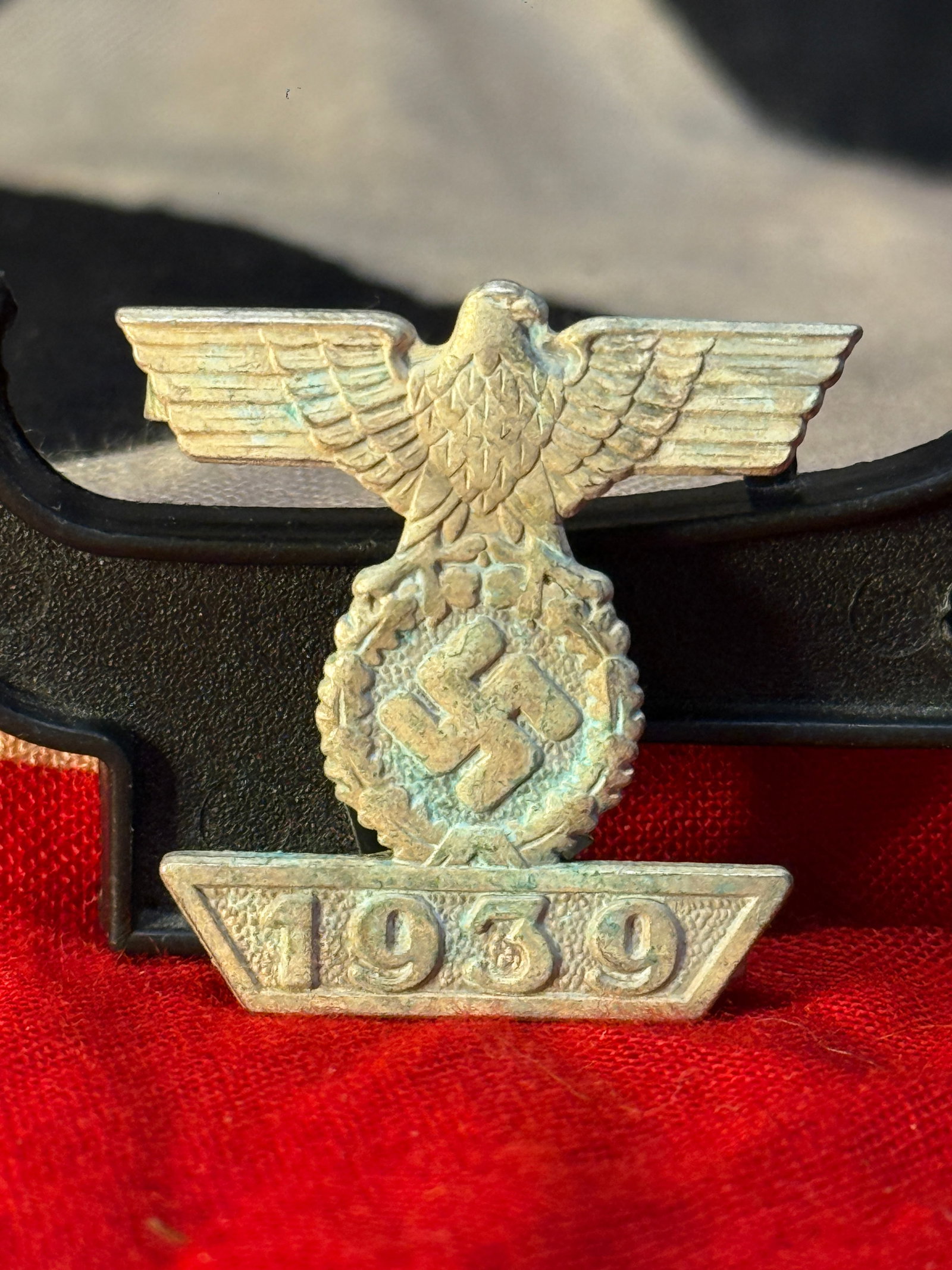 WWII German 1939 Bar to the Iron Cross 2nd Class Eagle Swastika Badge L/12: WWII German 1939 Bar to the Iron Cross badge featuring a spread-wing eagle above a wreath and swastika, with the raised date “1939” along the bottom. The reverse has two horizontal attachment 