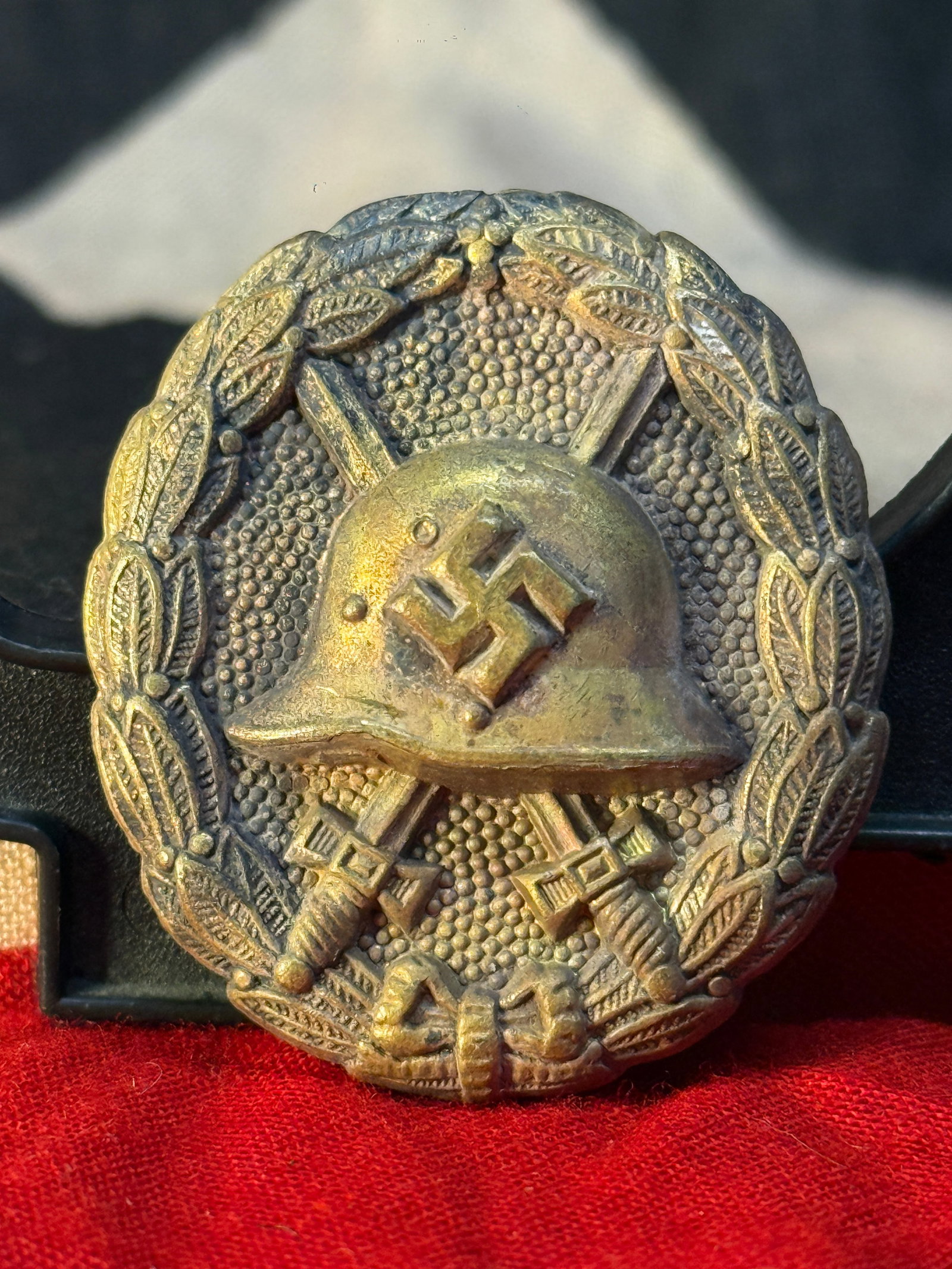 WWI German Wound Badge in Black: This WWI German Wound Badge in Black features a Stahlhelm helmet bearing a swastika over crossed swords enclosed within a laurel wreath. The reverse retains its original pin and hinge assembly, while 