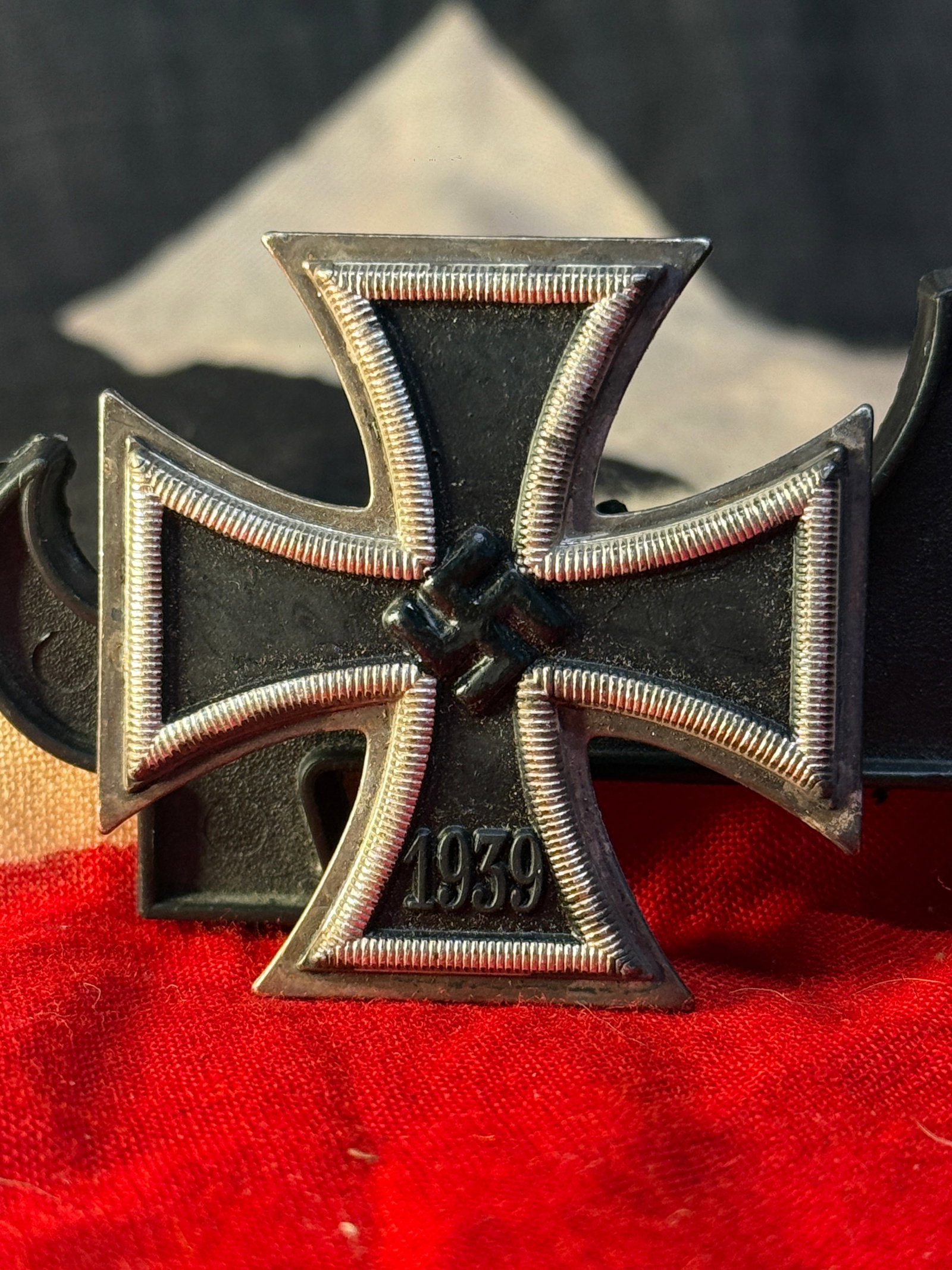 WWII German Iron Cross 2nd Class 1939 Medal: The iconic WWII German Iron Cross 2nd Class (Eisernes Kreuz 2. Klasse 1939) features a magnetic iron core with a black finish surrounded by a silvered frame. The obverse displays a raised swastika abo