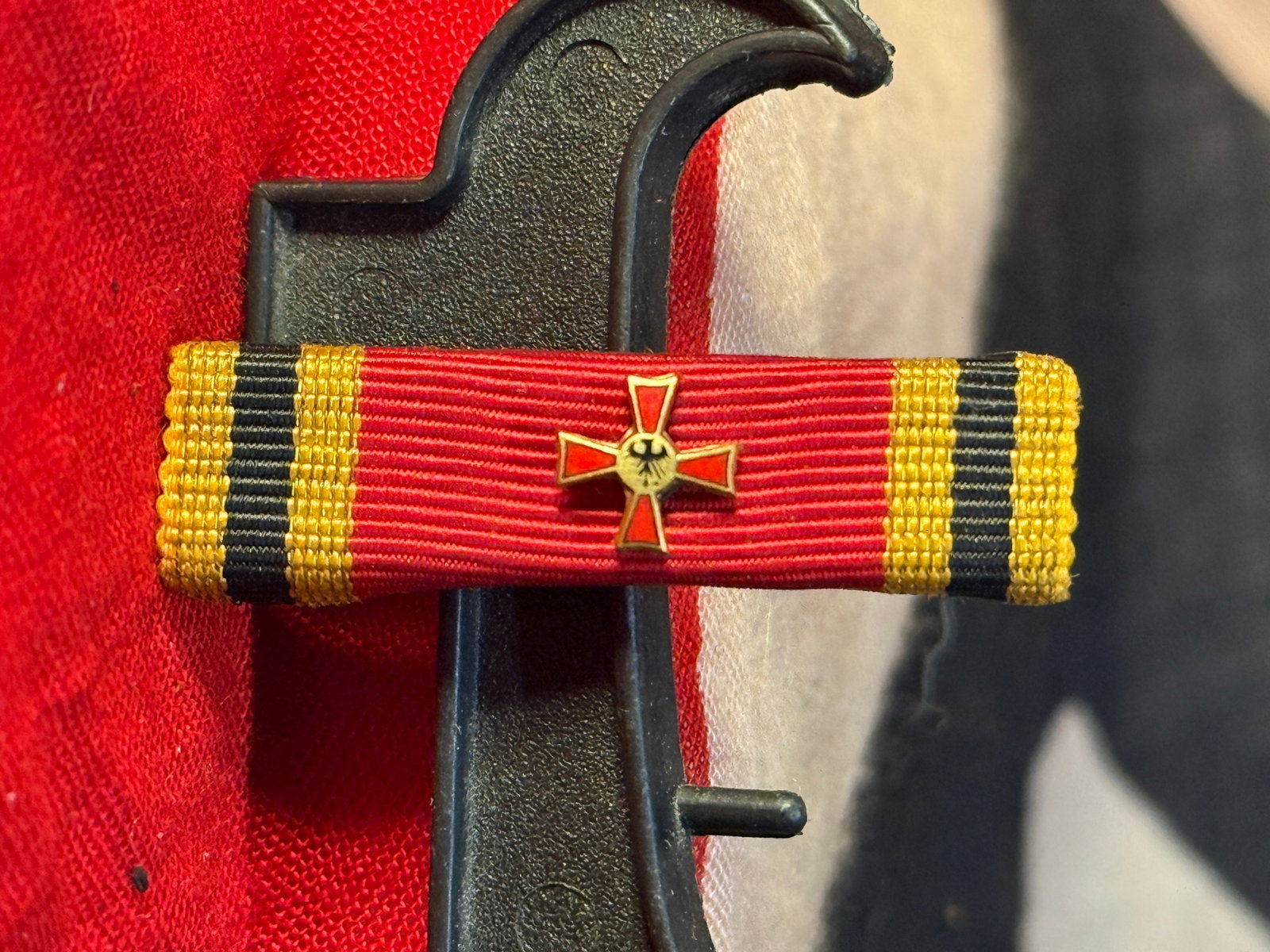WWII German War Merit Cross Ribbon Bar: This ribbon bar represents the War Merit Cross (Kriegsverdienstkreuz) and retains its original miniature War Merit Cross device mounted on the ribbon. Ribbon bars of this type were worn on German mili