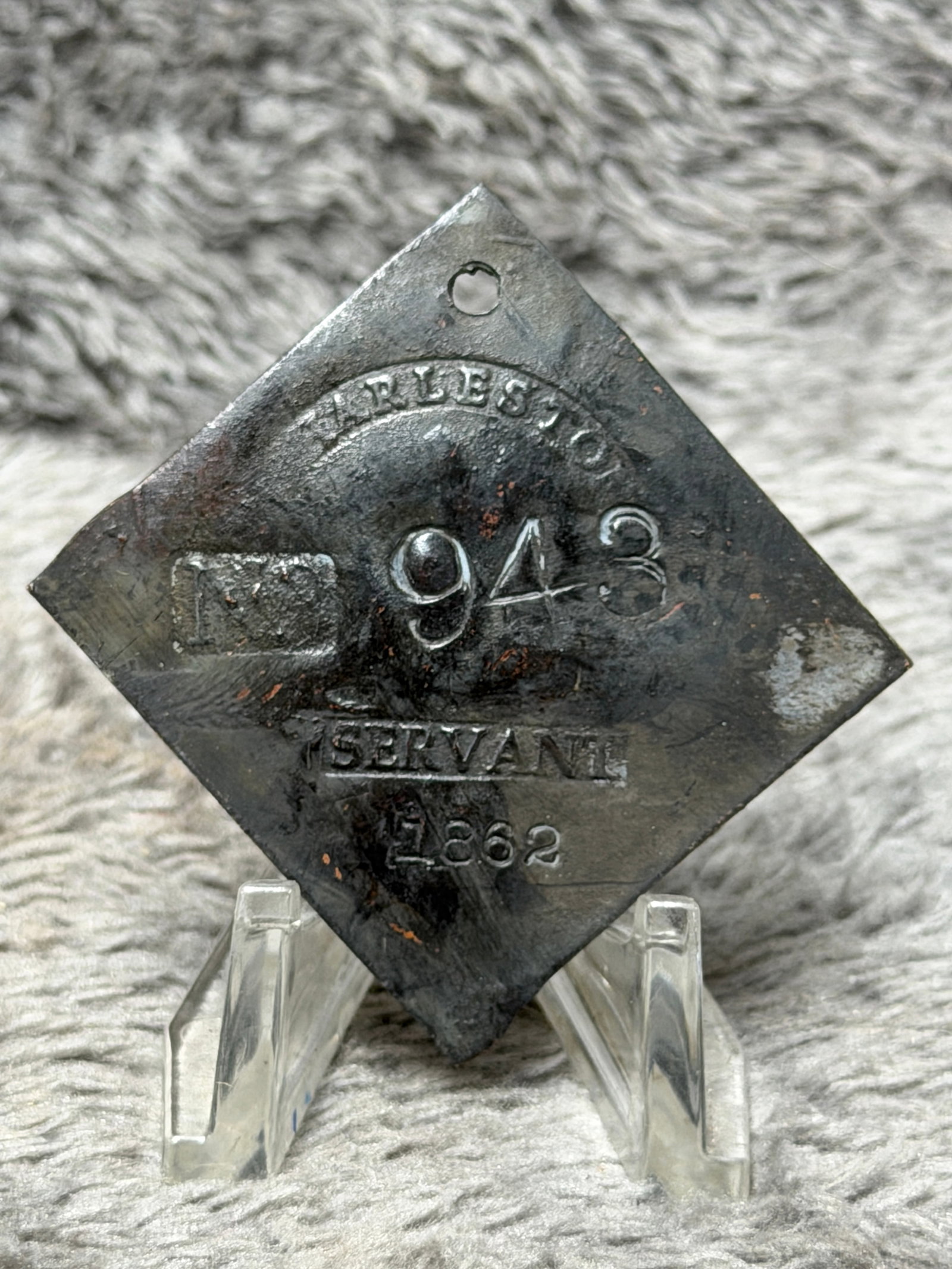 Dated 1862 Charleston Slave Tag No. 943 Servant Enslaved Hire Identification Badge: Dated 1862 diamond-shaped Charleston slave hire tag marked “CHARLESTON” across the top, numbered “943” at center, “SERVANT” below, and “1862” along the bottom. The tag 