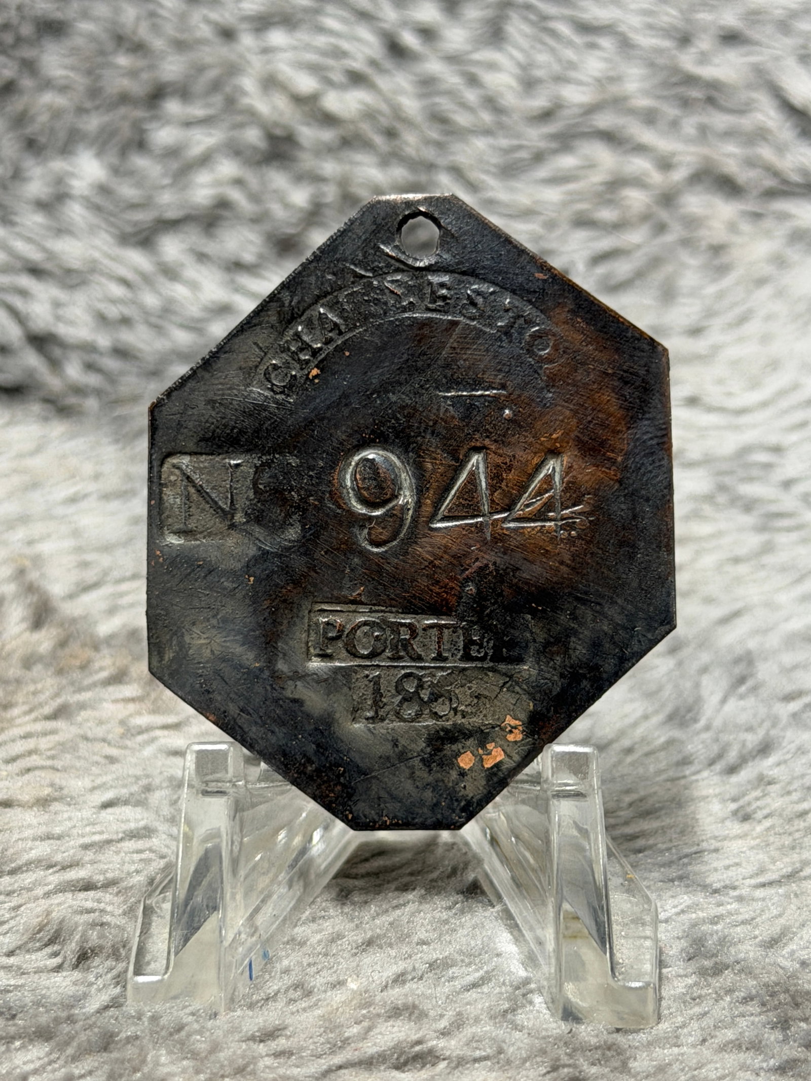 Dated 1835 Charleston Slave Tag No. 944 Porter Enslaved Hire Identification Badge: Multi-sided Charleston slave hire tag marked “CHARLESTON” in a curved banner across the upper portion, with the large identification number “944” prominently stamped at center, “PORT