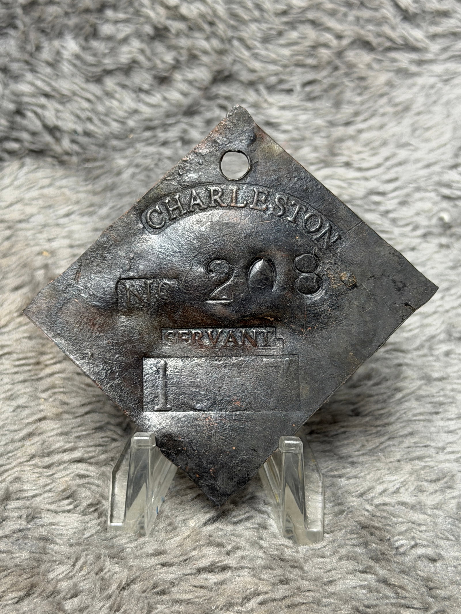 1837 Charleston No. 208 Servant Slave Hire Tag Diamond Shaped Historical Badge: Diamond-shaped metal tag featuring a curved “CHARLESTON” marking across the upper portion, “No 208” prominently stamped at center, “SERVANT” below, and what appears to be the d