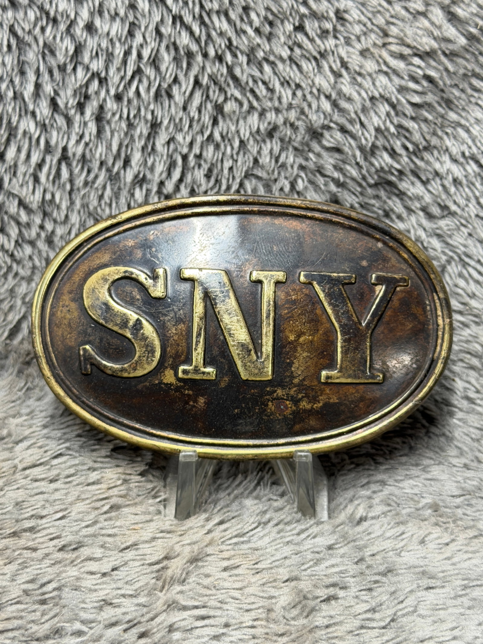 Civil War New York State Militia “SNY?? Oval Belt Plate – Union Military Buckle: This impressive Civil War-era oval belt plate features the prominent raised letters “SNY,” representing the State of New York, displayed across a darkened field and enclosed by a raised double