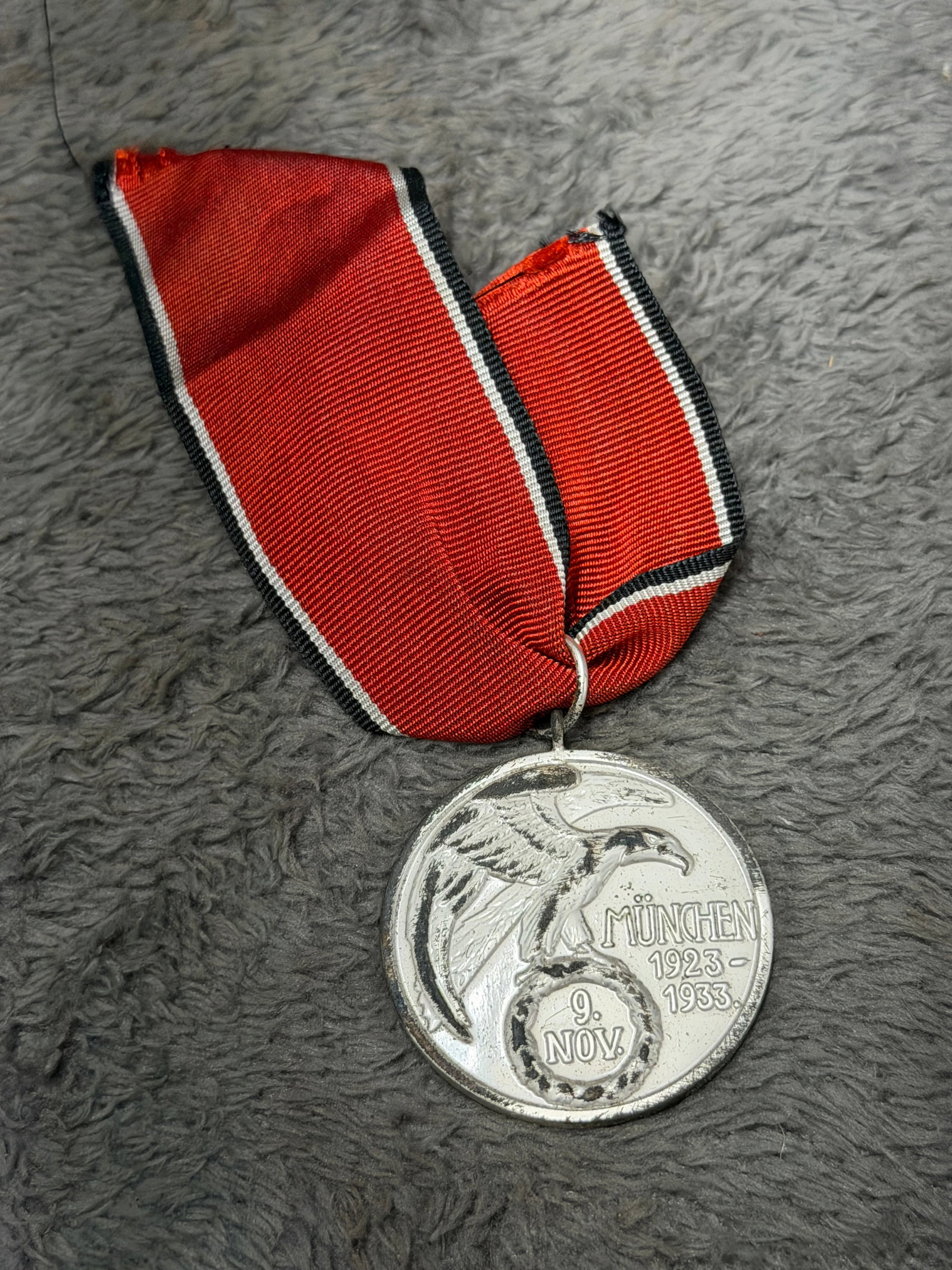 WWII German 1923–1933 Munich 9 November Blood Order Commemorative Medal: A striking WWII German political commemorative medal honoring the events associated with Munich on November 9, 1923, and their tenth anniversary in 1933. The circular silver-tone medal features a prom