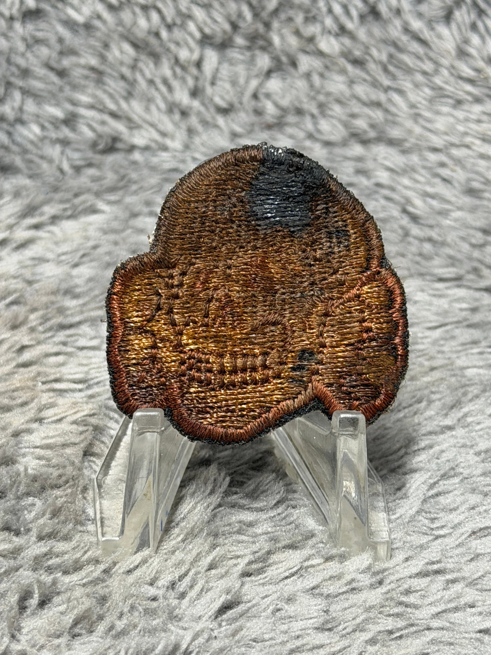 WWII German Waffen-SS Totenkopf Skull Embroidered Cloth Badge Insignia: WWII German Waffen-SS Totenkopf skull cloth badge featuring an embroidered skull-and-crossbones motif executed in dense threadwork on a shaped textile backing. The Totenkopf, or “death’s head,&rdq